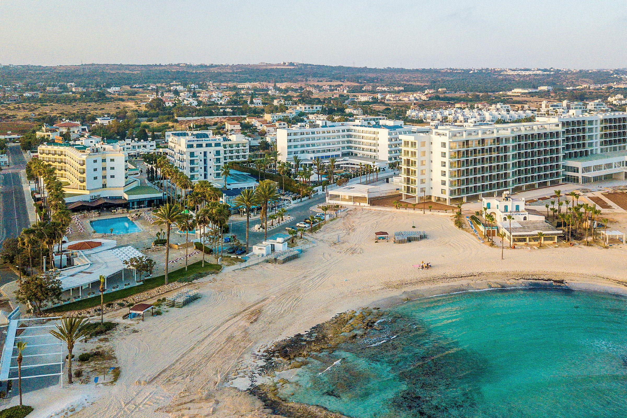 Udsigt over flere hotelbygninger ved en strand. (AI-genereret tekst)