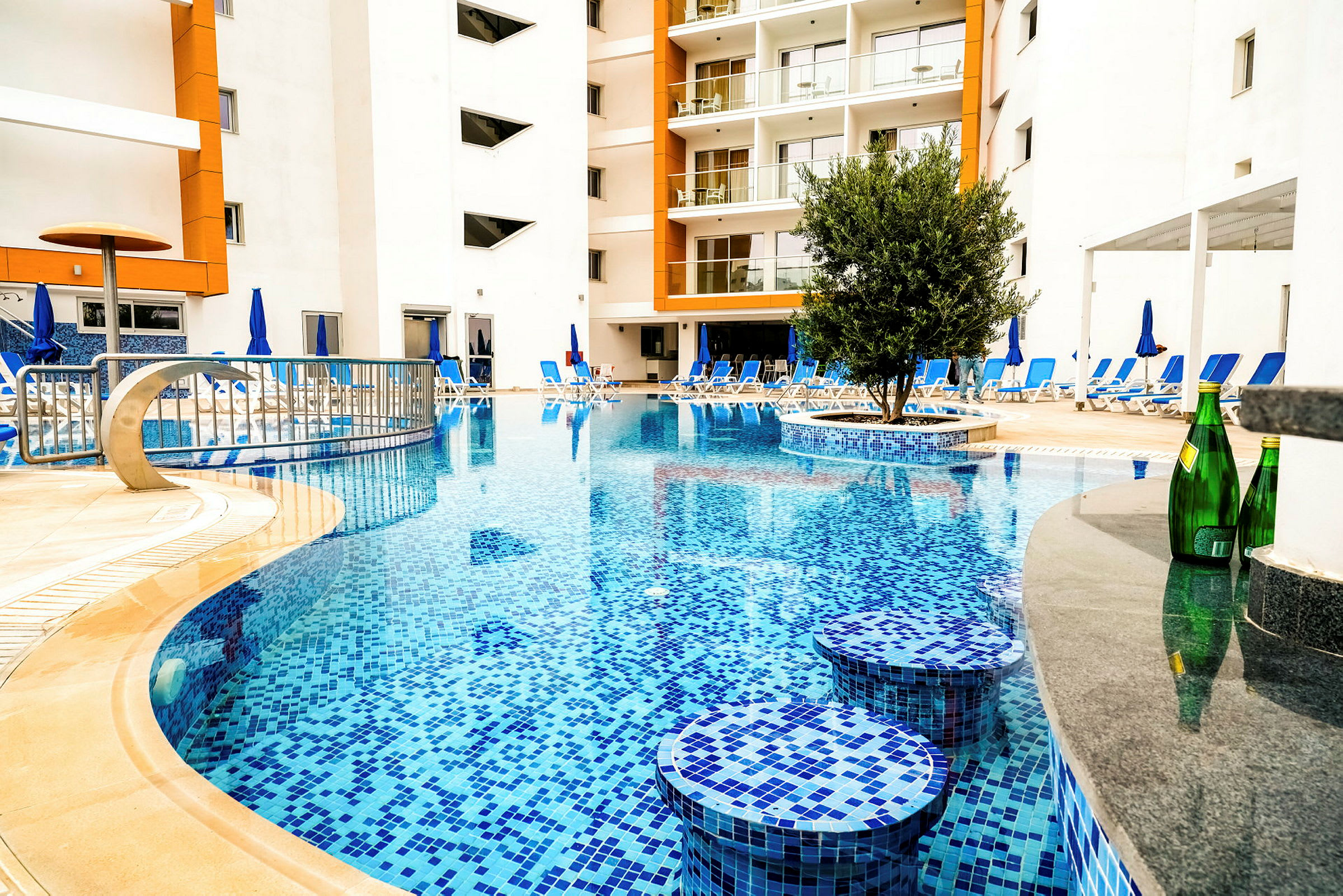 Poolområde med liggestole omkring ved et hotel. (AI-genereret tekst)
