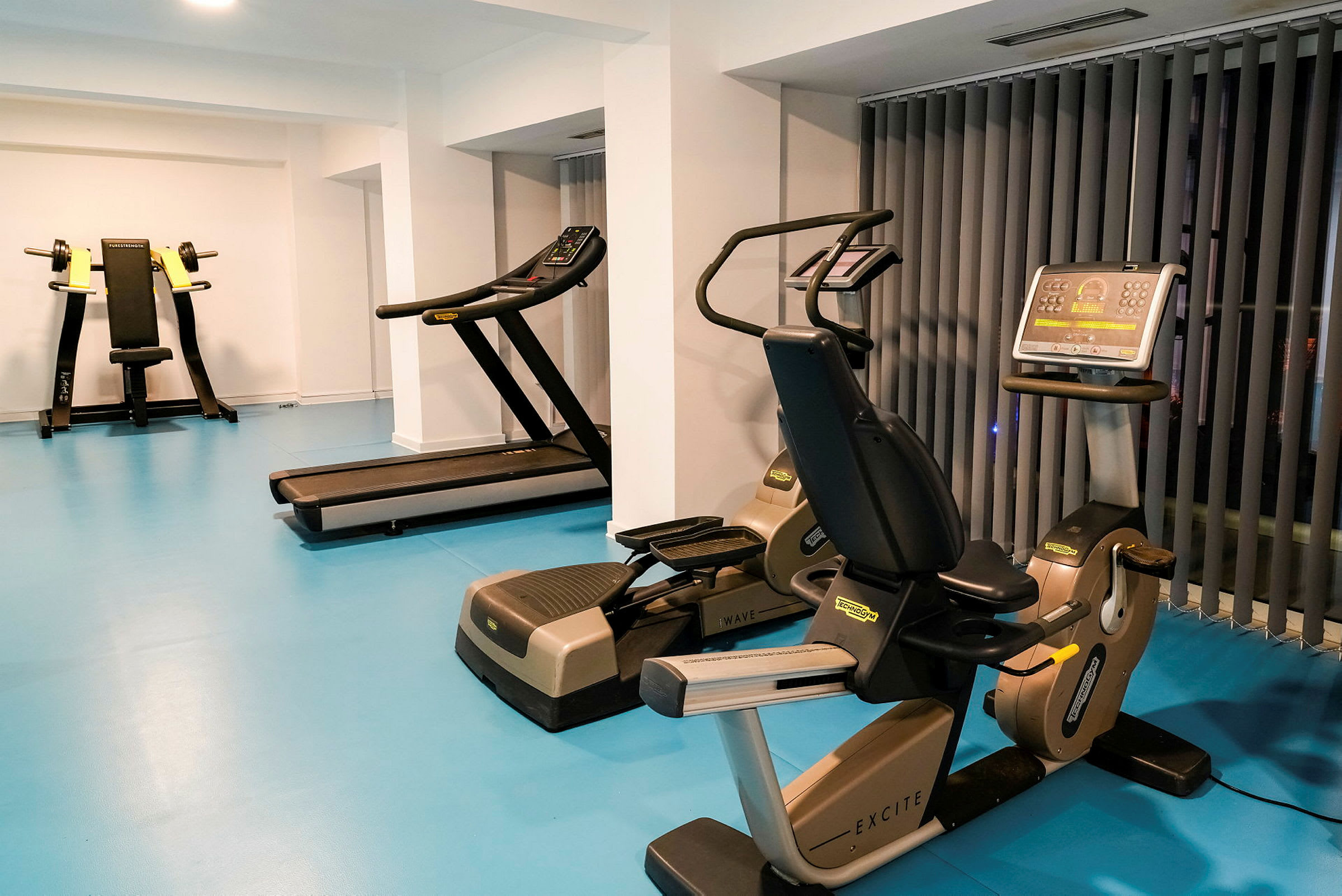 Et fitnesscenter med træningsmaskiner, inklusive løbebånd og motionscykler. (AI-genereret tekst)