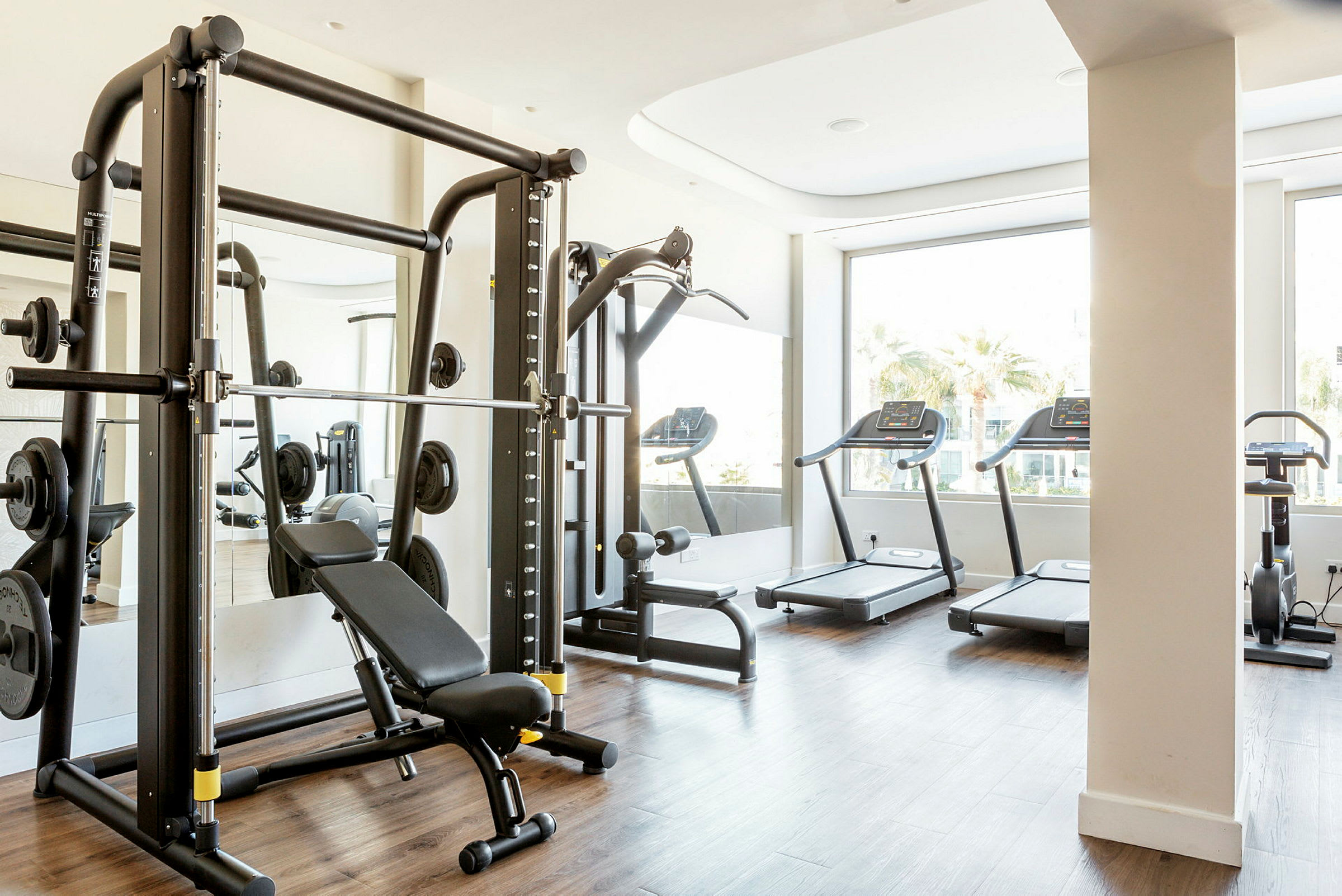 Fitnesscenter med forskellige træningsmaskiner. (AI-genereret tekst)