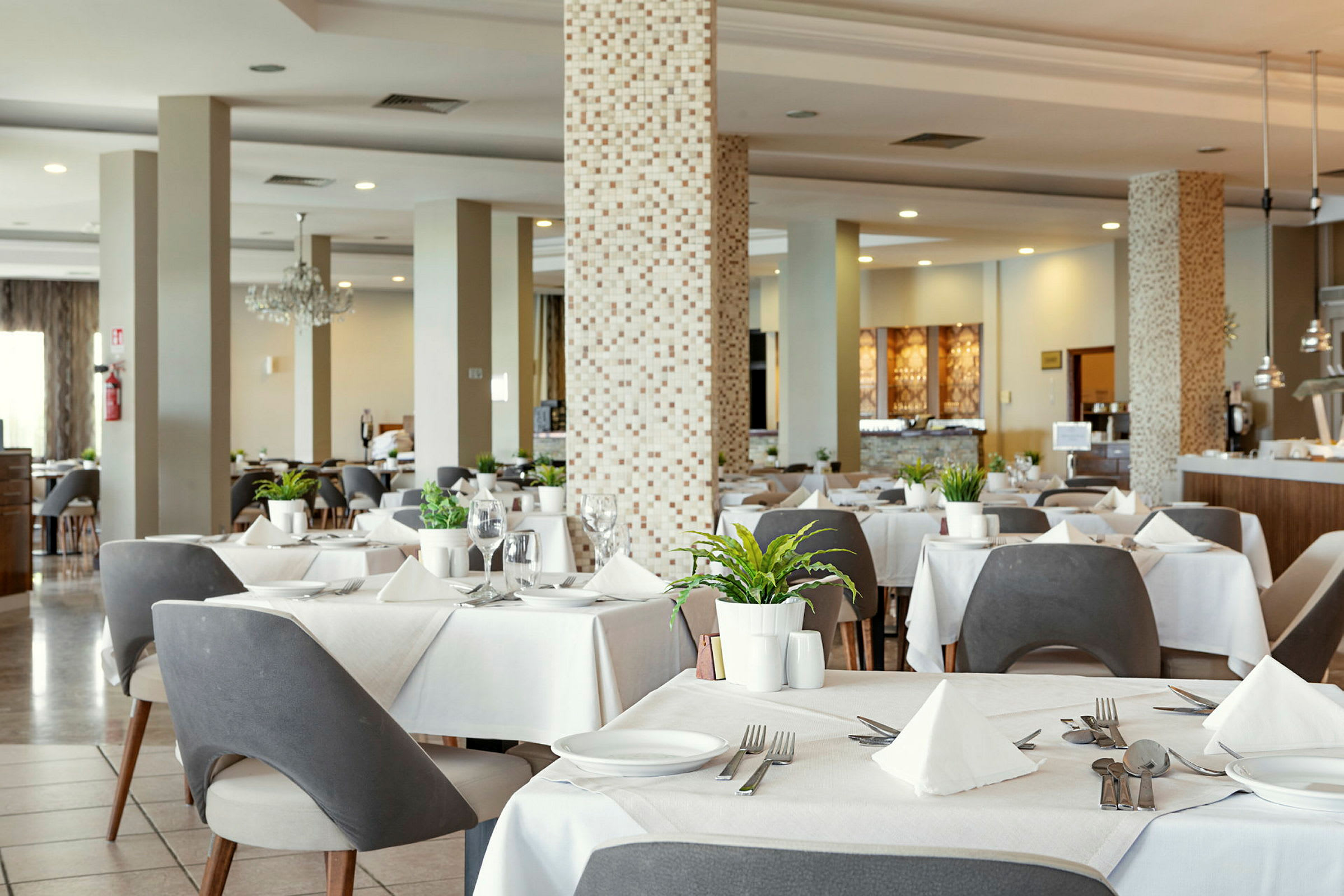 Restaurant med dækkede borde, moderne stole og dekorationer. (AI-genereret tekst)
