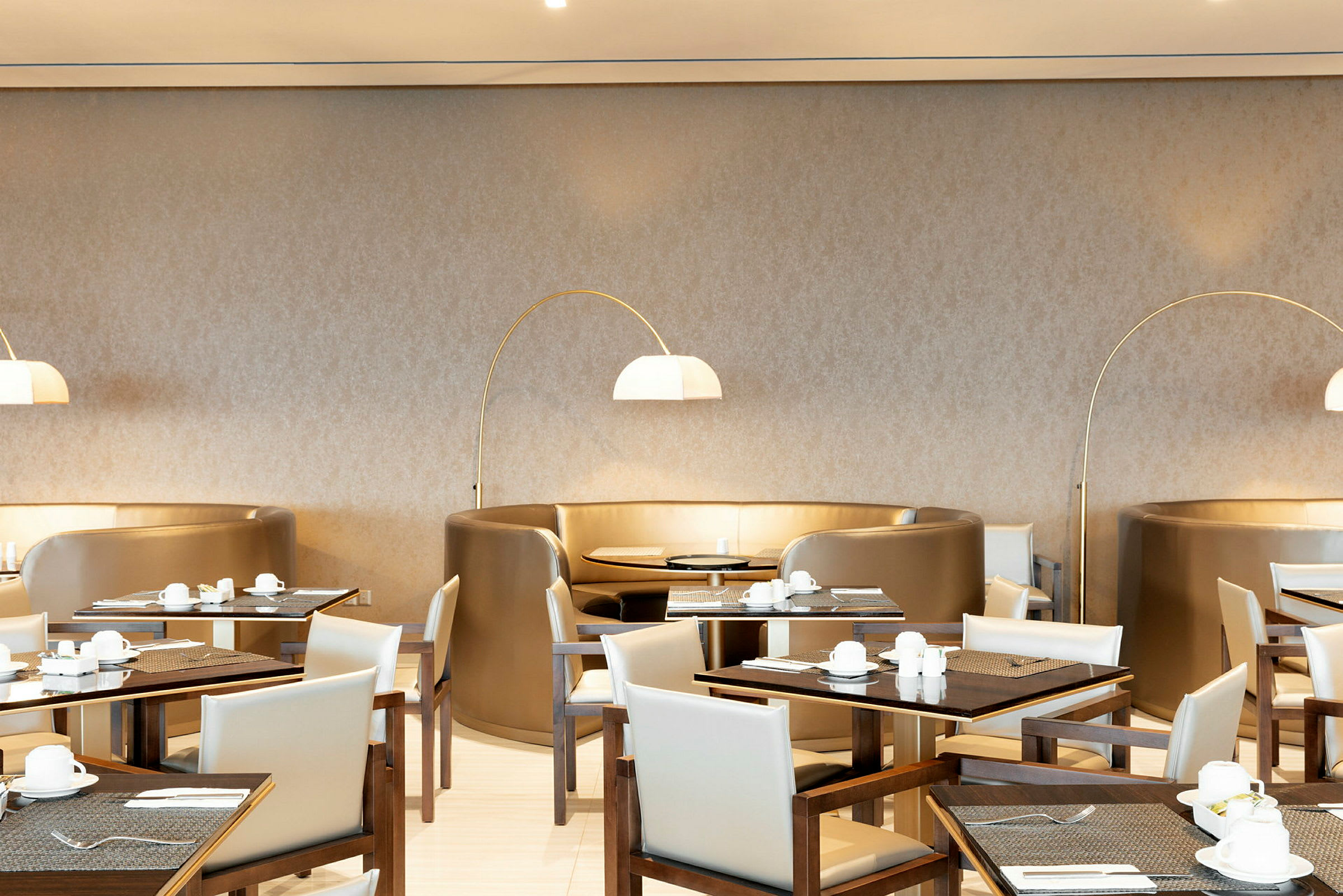 Restaurant med borde, stole og buede siddepladser. (AI-genereret tekst)