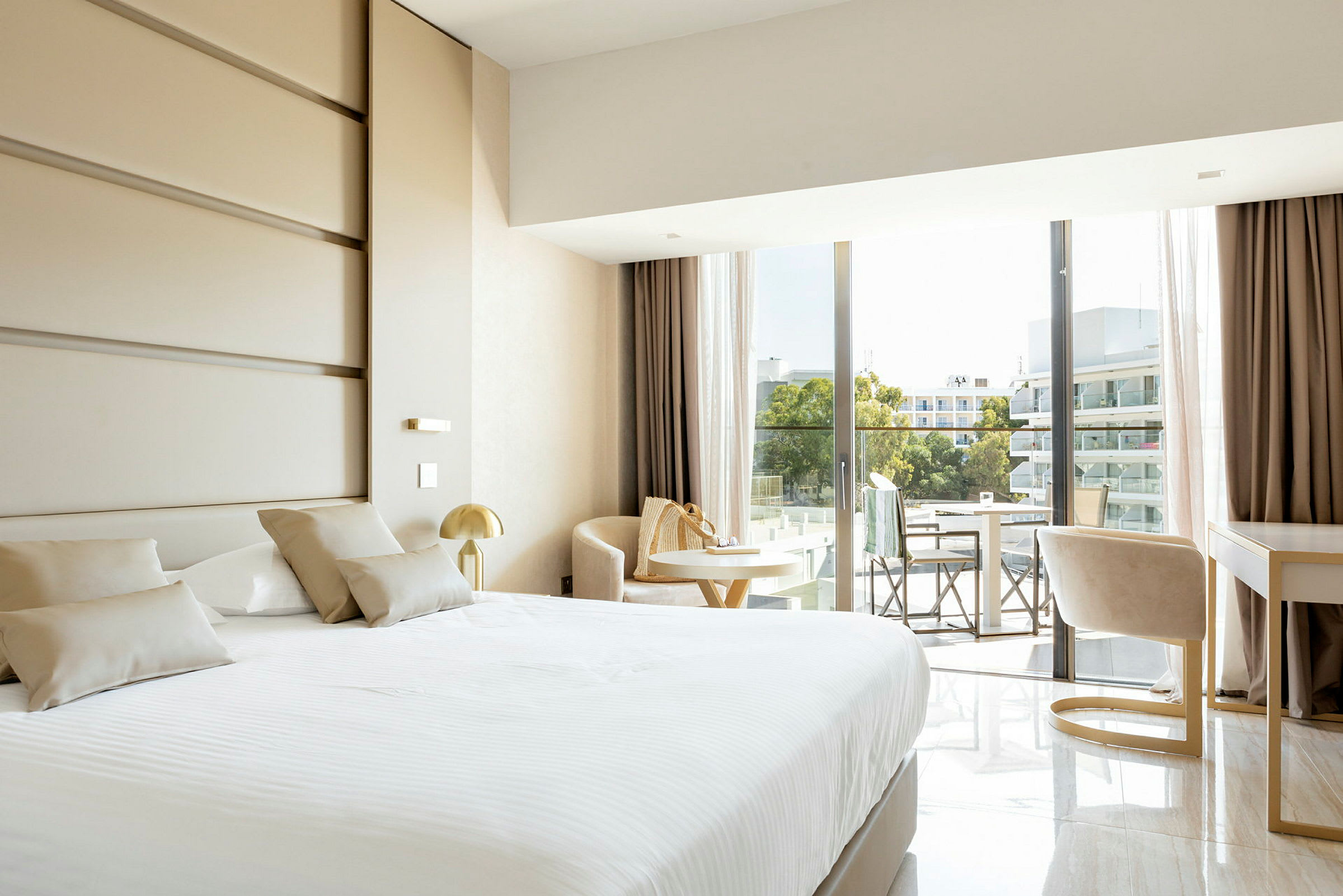 Moderne hotelværelse med seng, siddeområde og en balkon med udsigt. (AI-genereret tekst)