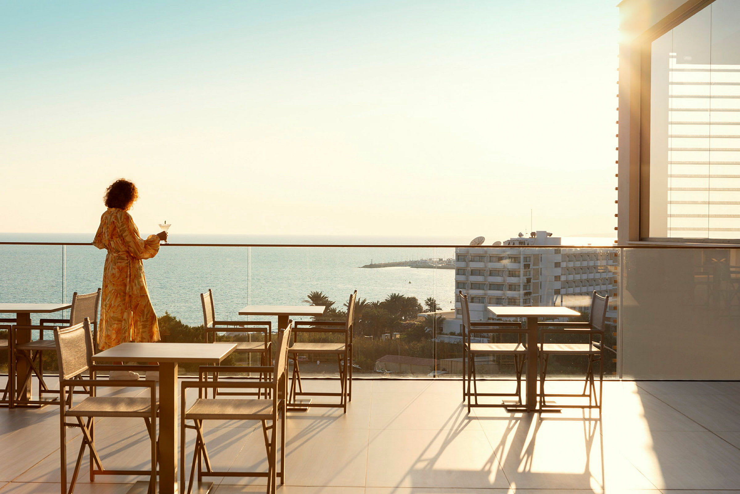Person på en terrasse med udsigt over havet. (AI-genereret tekst)