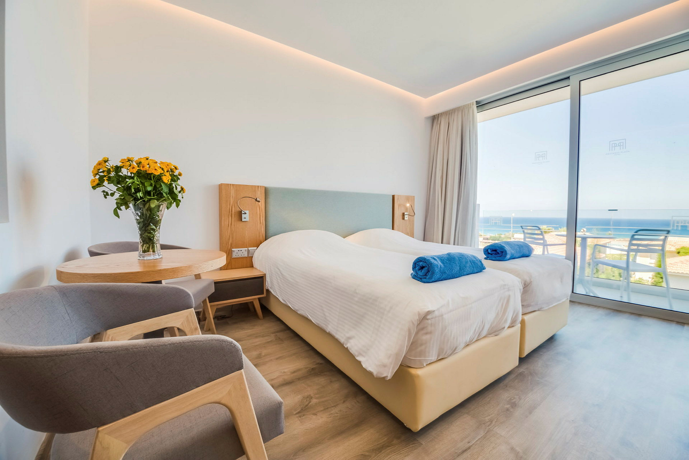 Hotelværelse med to enkeltsenge, udsigt over havet. (AI-genereret tekst)