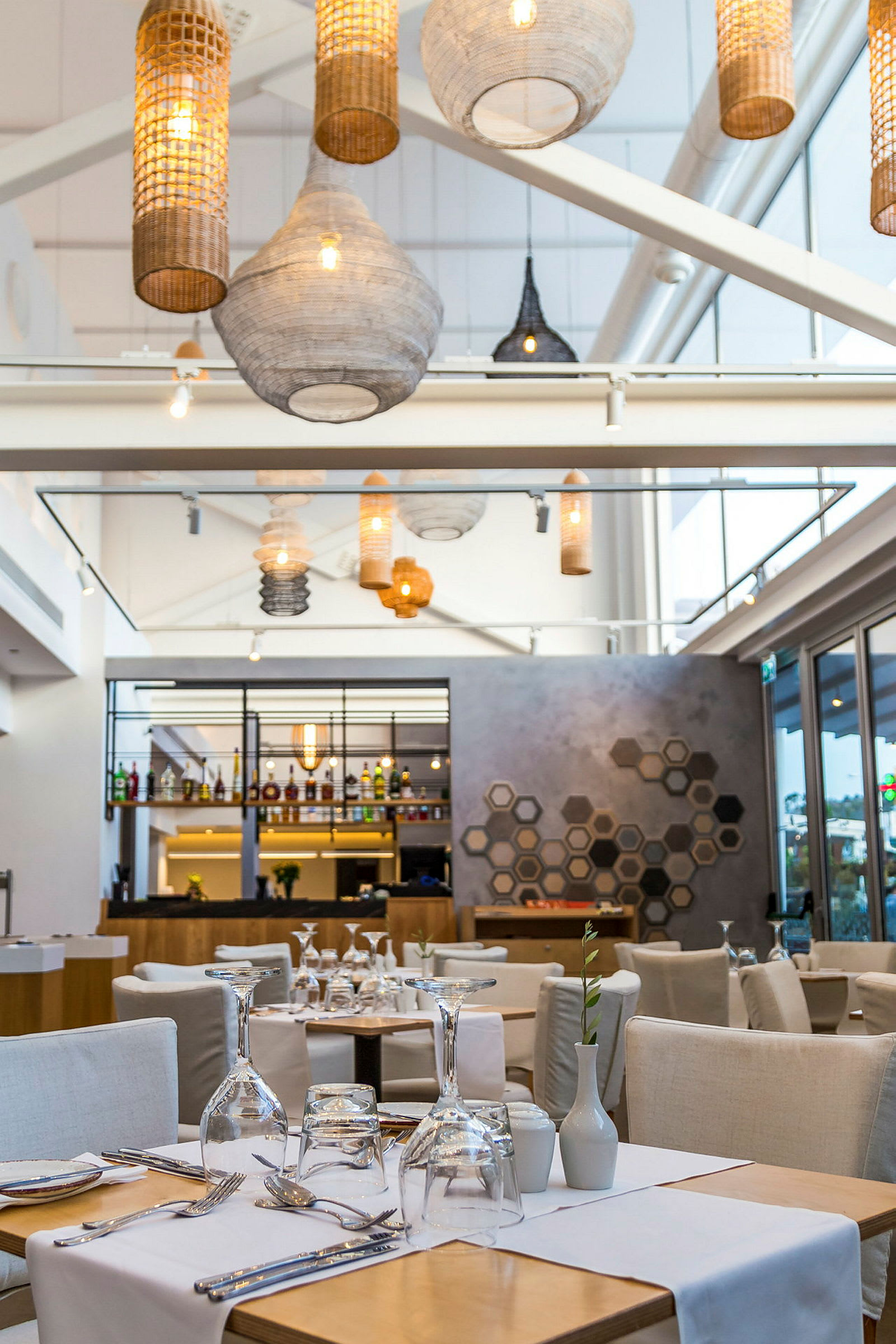 En moderne restaurant med elegant interiør, hvide borde og glasdetaljer. (AI-genereret tekst)