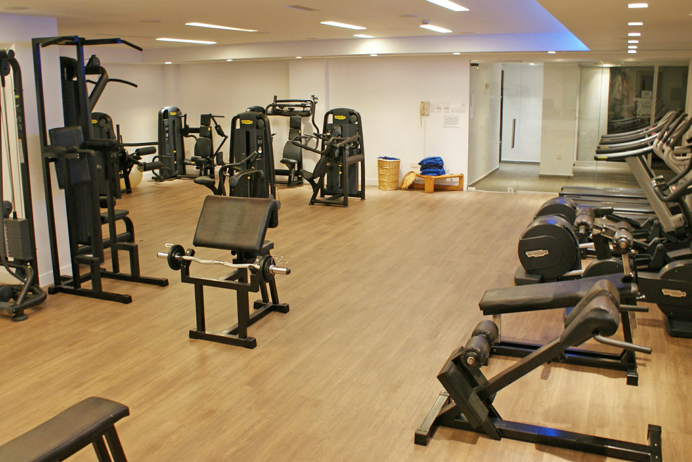 Fitnessrum med forskellige træningsmaskiner og udstyr. (AI-genereret tekst)
