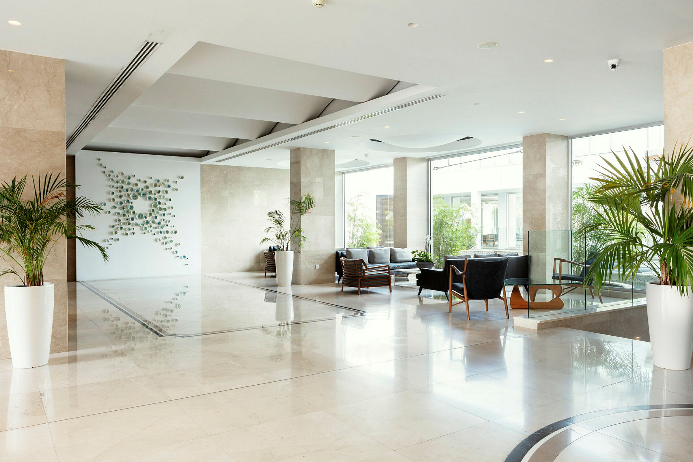 Moderne hotellobby med siddeområder og planter. (AI-genereret tekst)