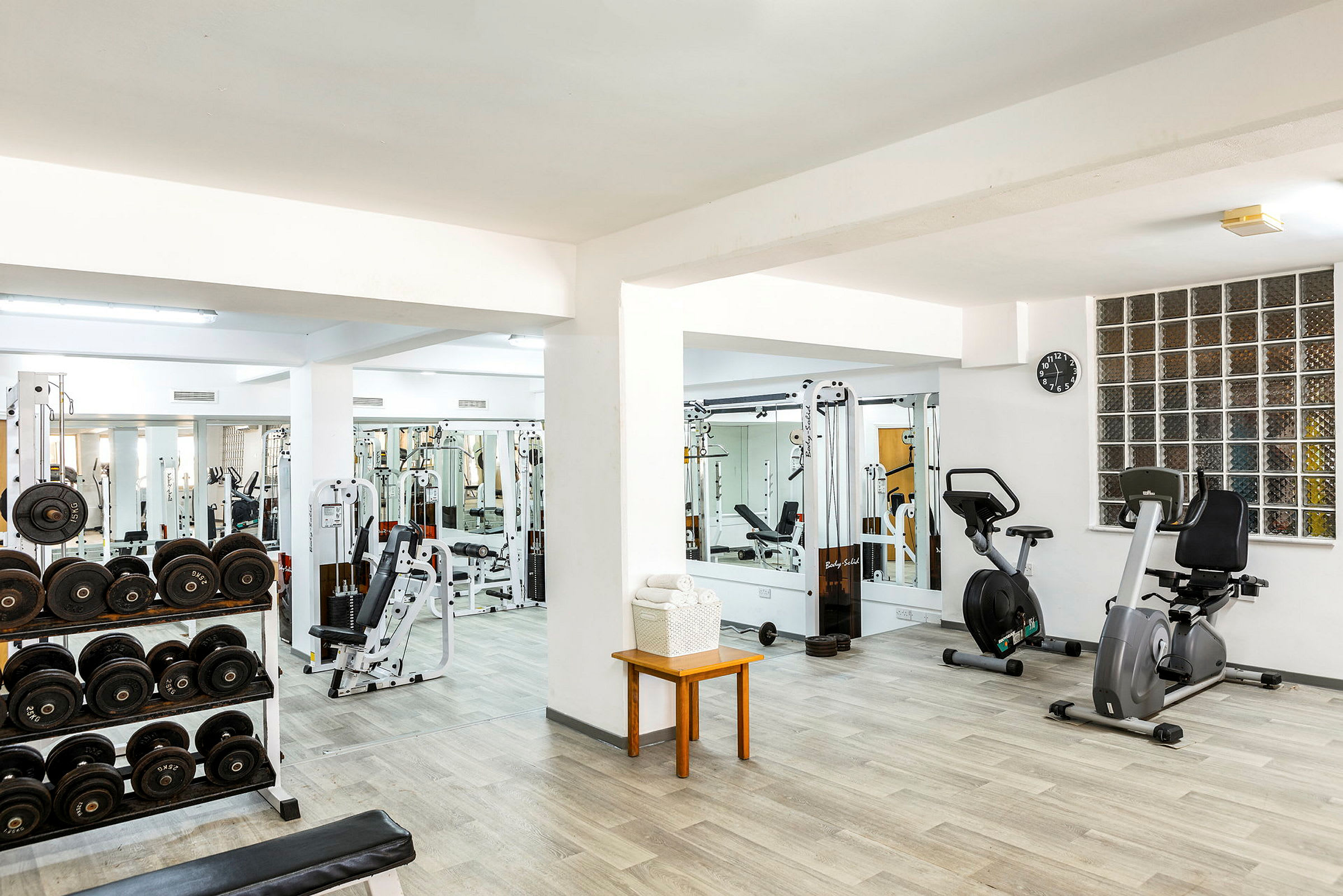 Fitnesscenter med træningsmaskiner, håndvægte og motionscykler. (AI-genereret tekst)