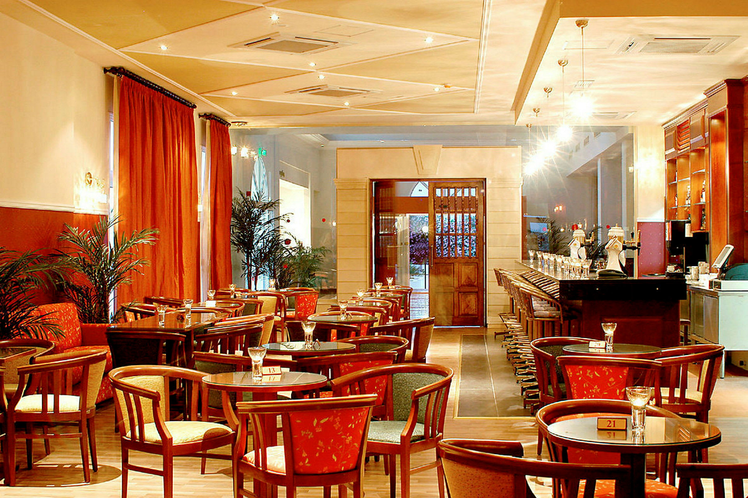 Interiør af en restaurant med borde, stole og bar. (AI-genereret tekst)