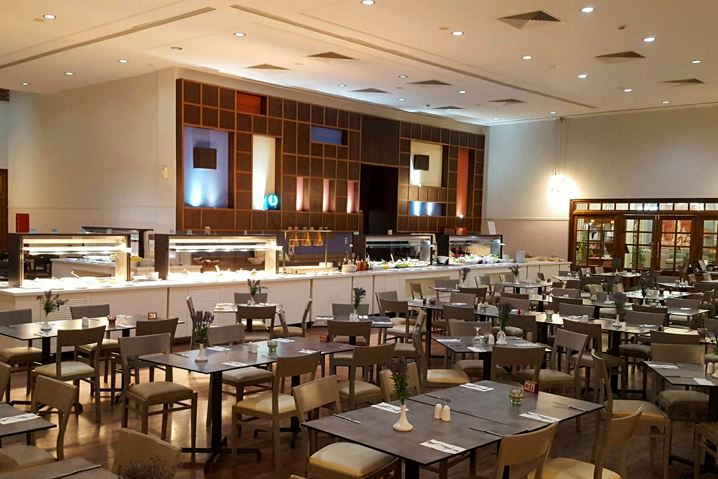 En restaurant med buffetområde og spiseborde. (AI-genereret tekst)