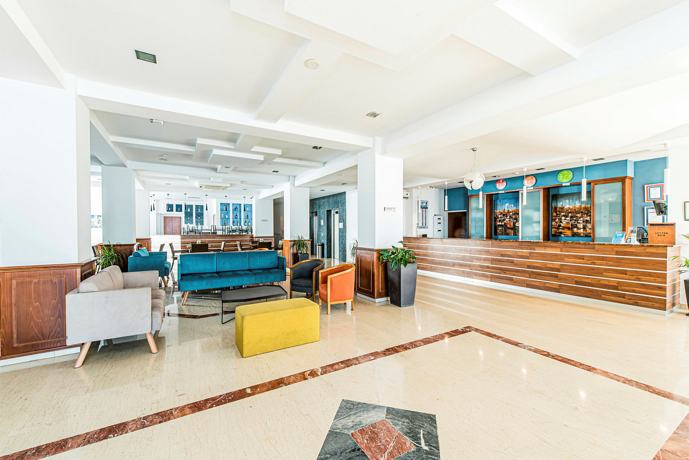En lys hotellets foyer med siddegrupper og reception. (AI-genereret tekst)