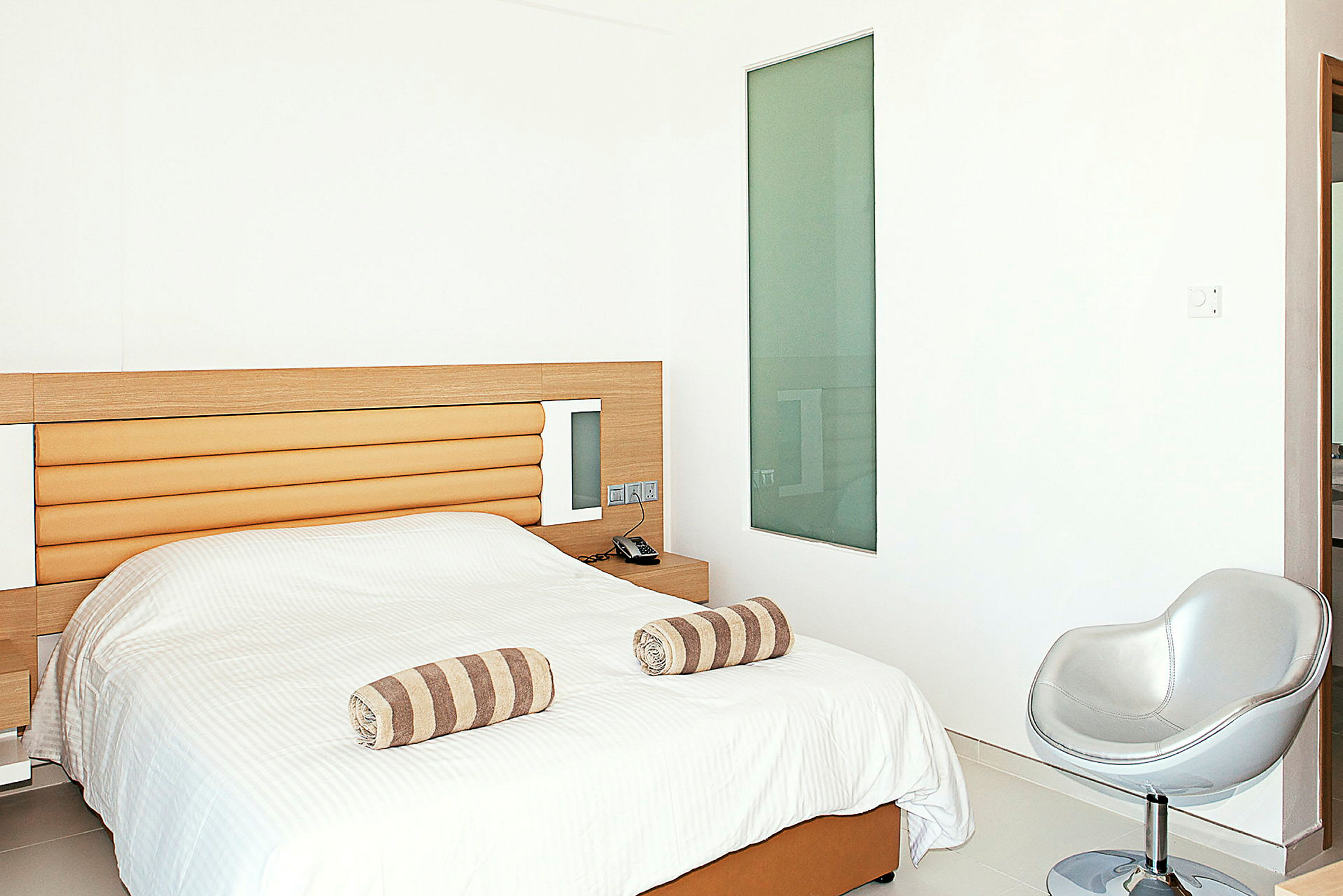 Hotelværelse med en seng og minimalistisk indretning. (AI-genereret tekst)