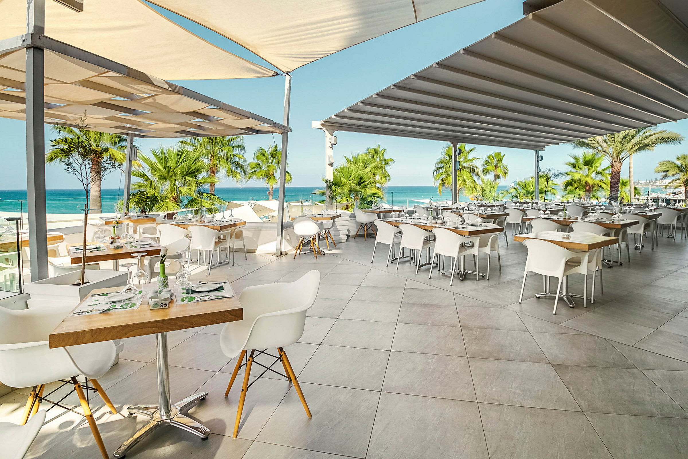 Restaurant med udendørs servering, udsigt over havet. (AI-genereret tekst)