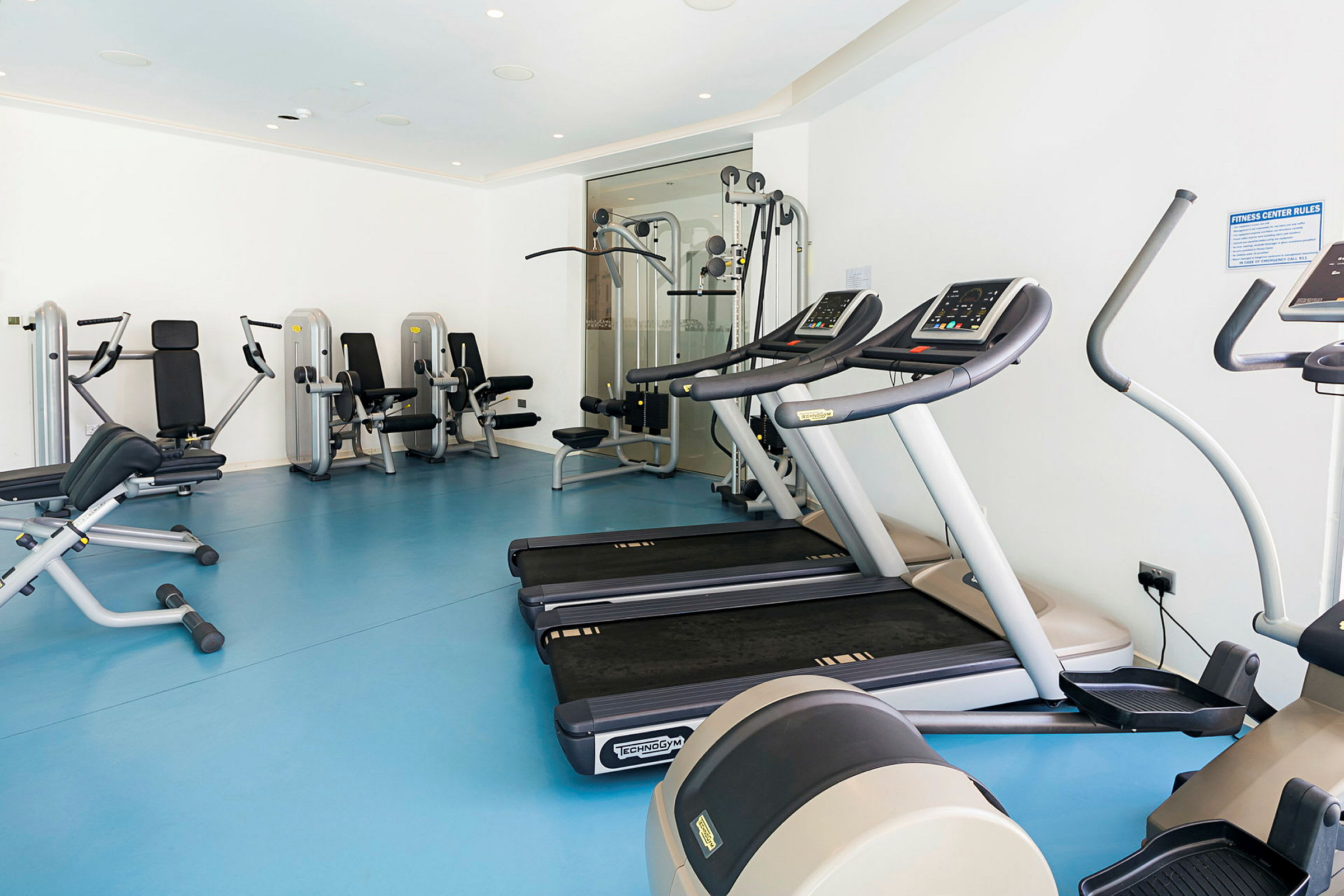 Fitnesscenter med træningsudstyr såsom løbebånd og styrkemaskiner. (AI-genereret tekst)