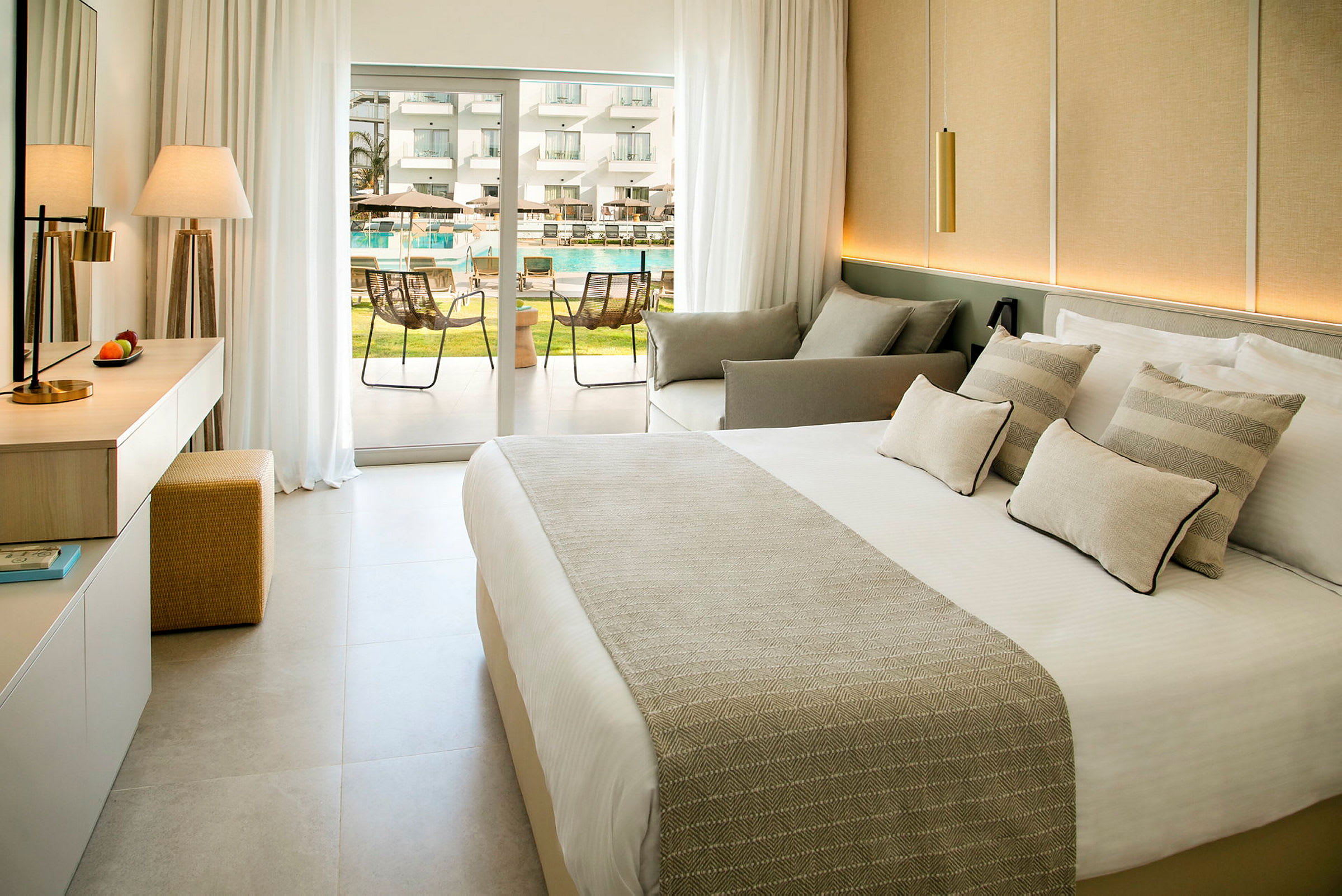 Moderne hotelværelse med seng, siddeområde og fransk dør til poolområdet. (AI-genereret tekst)