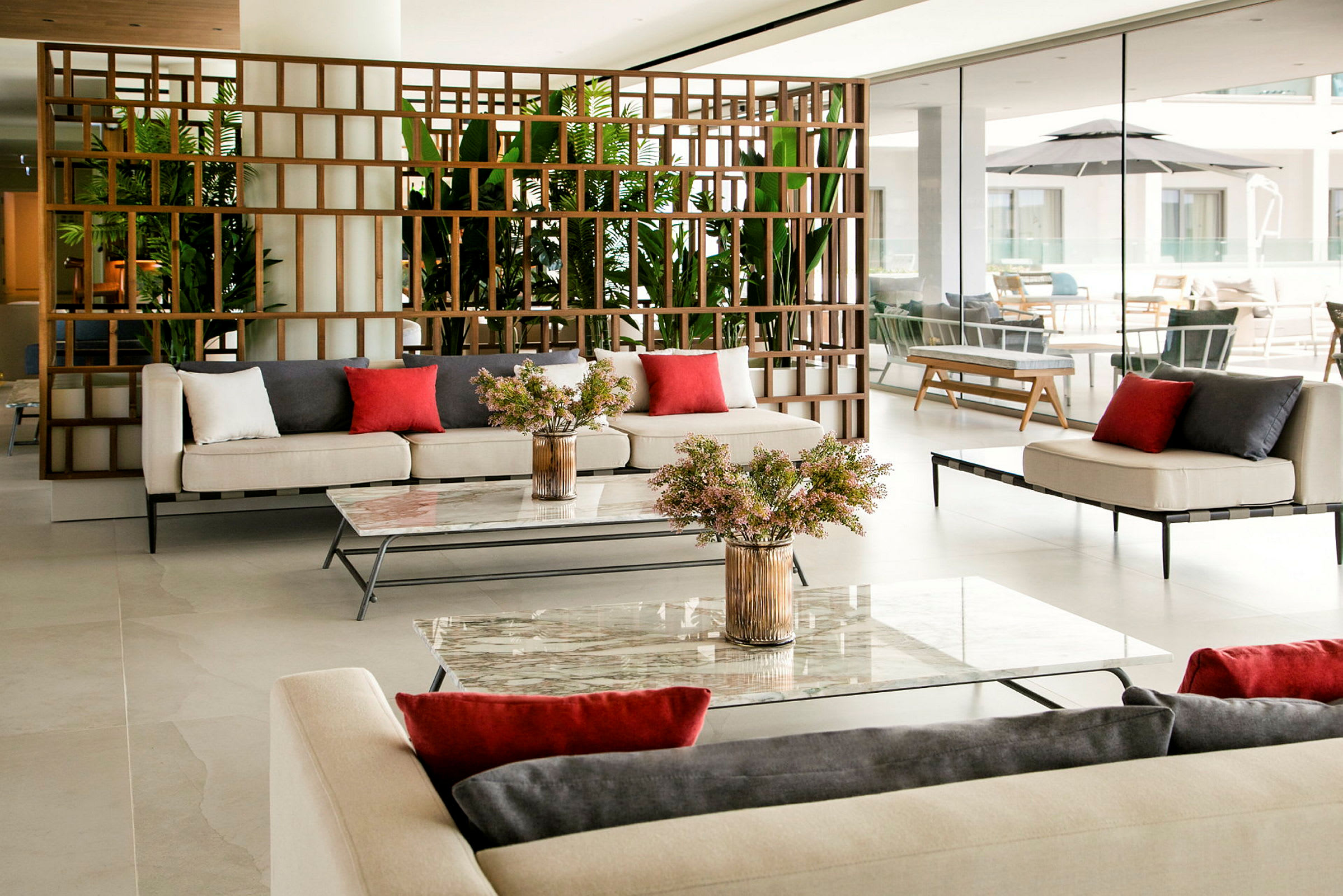 En moderne lounge med sofaer, borde og grønne planter. (AI-genereret tekst)