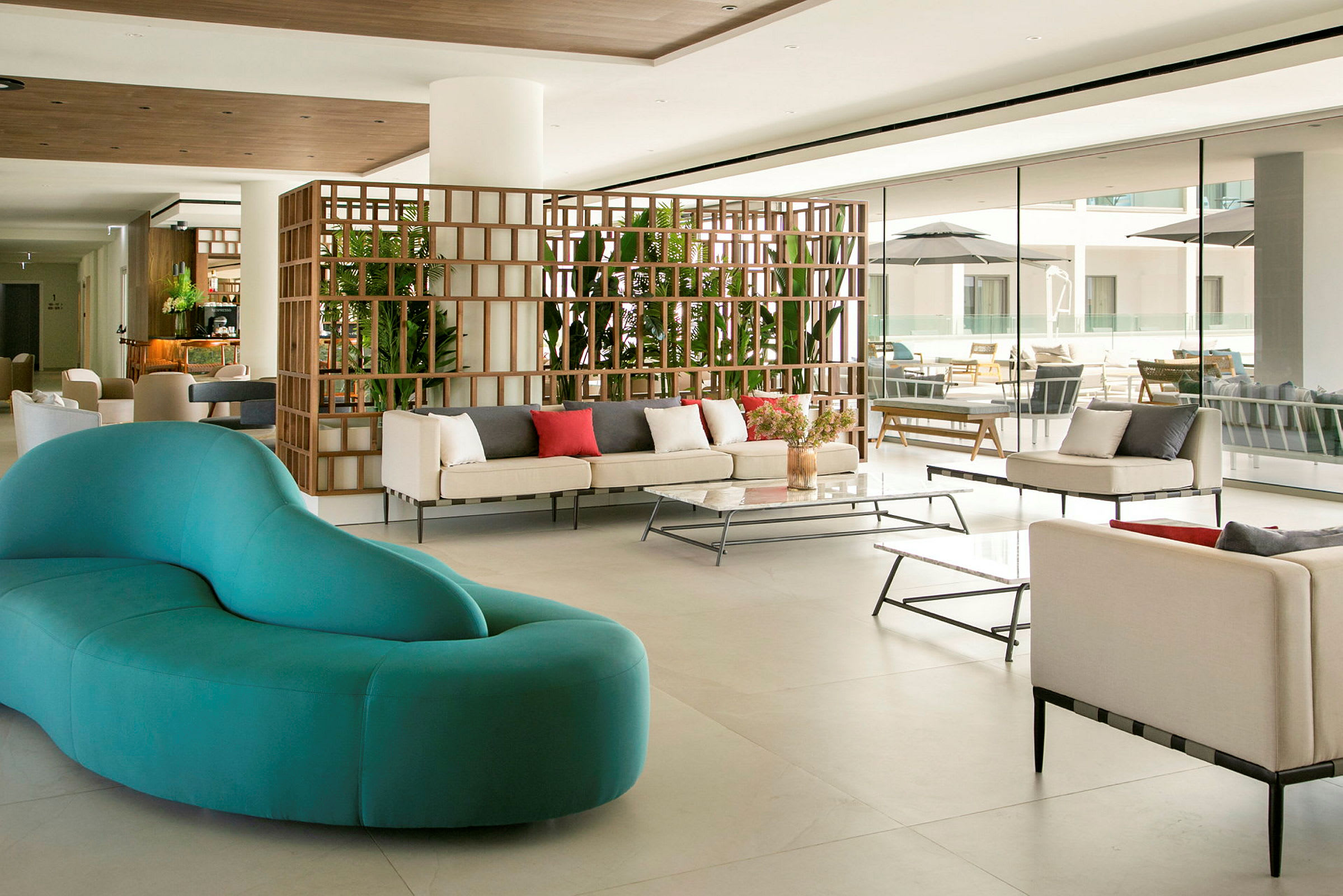 En moderne hotellobby med sofaer, borde og planter. (AI-genereret tekst)