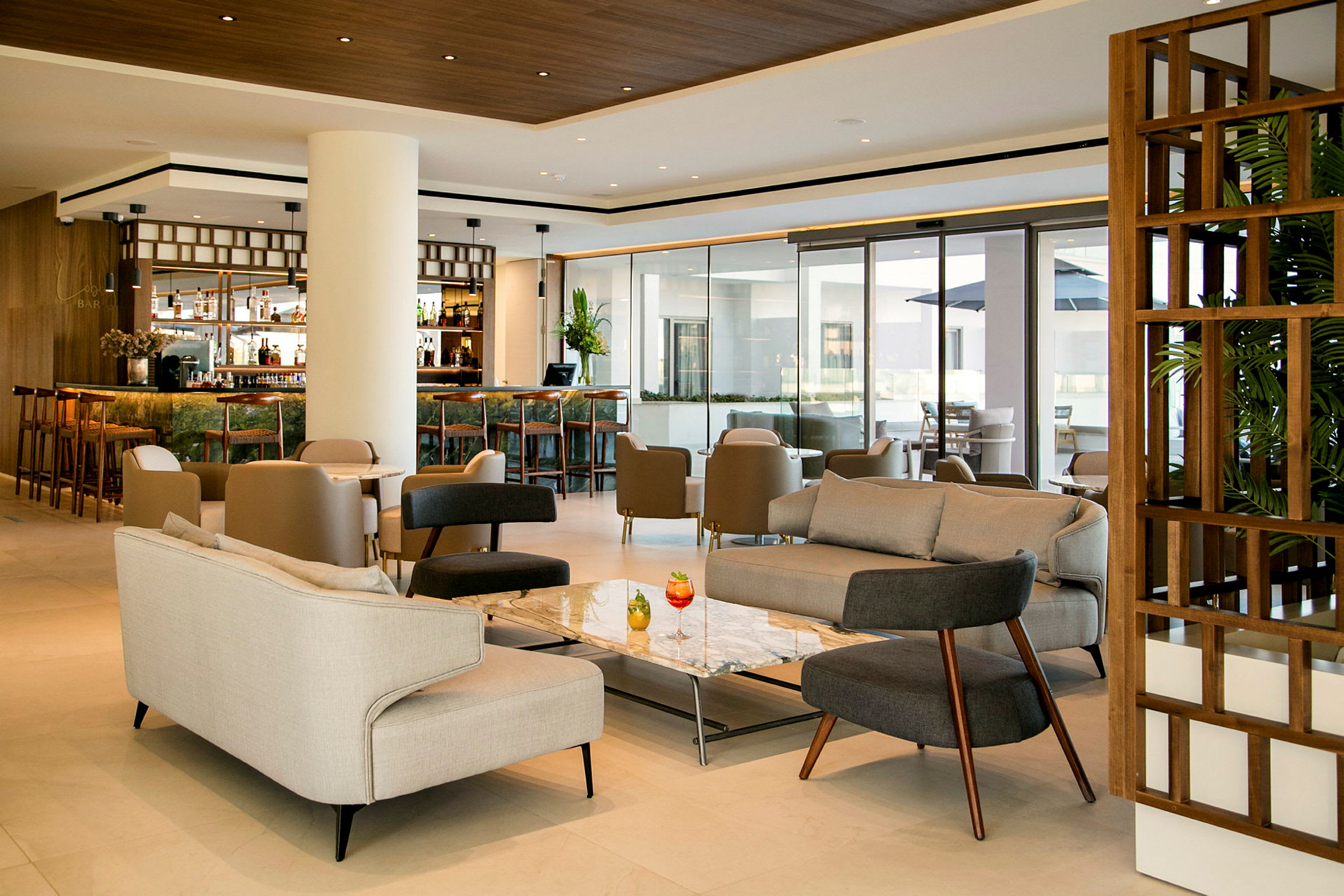 En elegant hotellobby med siddepladser og en bar. (AI-genereret tekst)