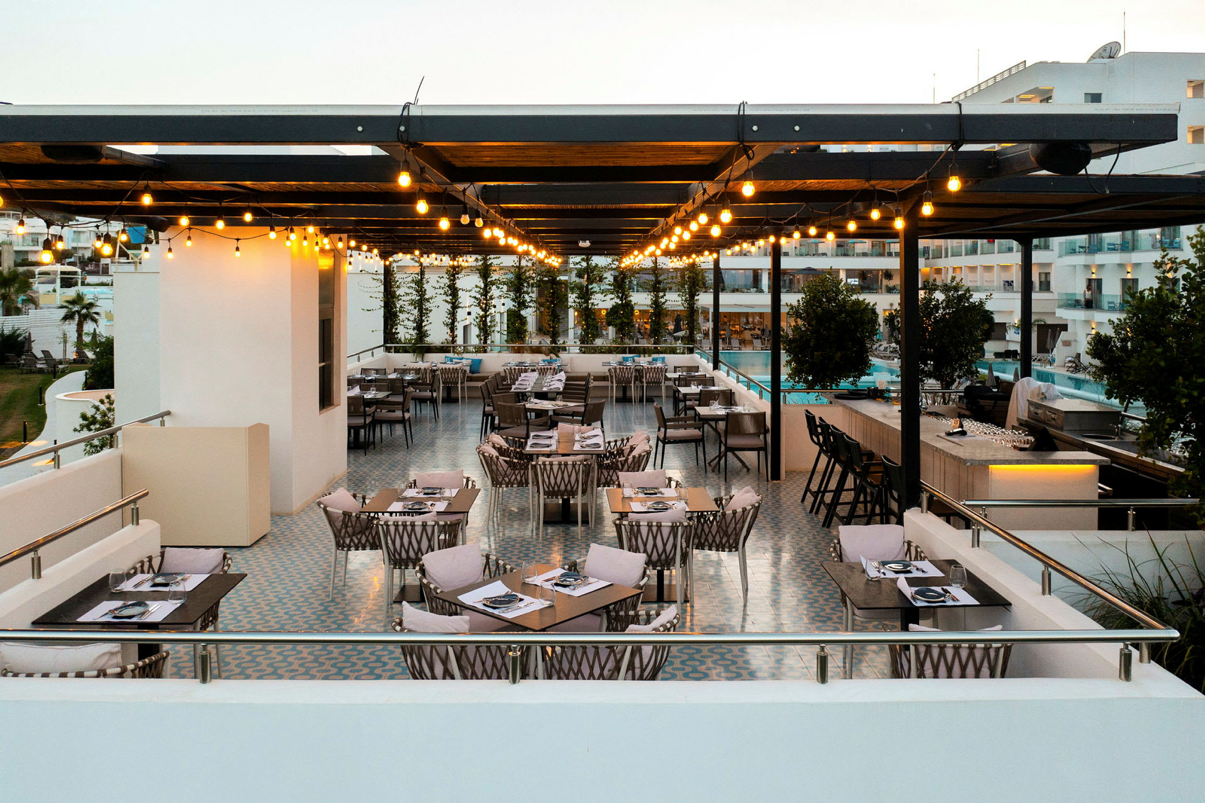 Udendørs serveringsområde med møbler og belysning under en pergola. (AI-genereret tekst)