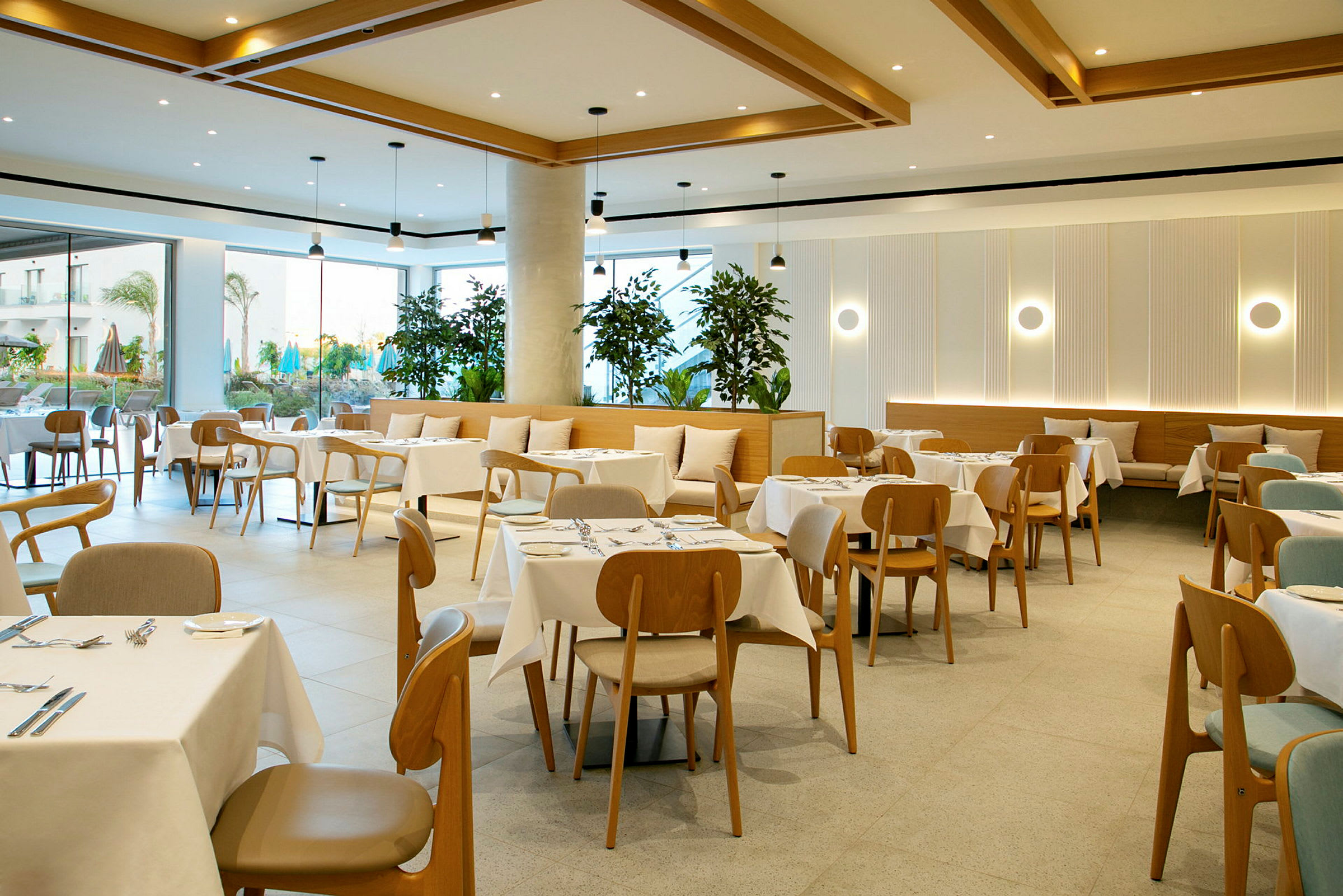 En moderne restaurant med dækkede borde og træstole samt dekorative planter. (AI-genereret tekst)