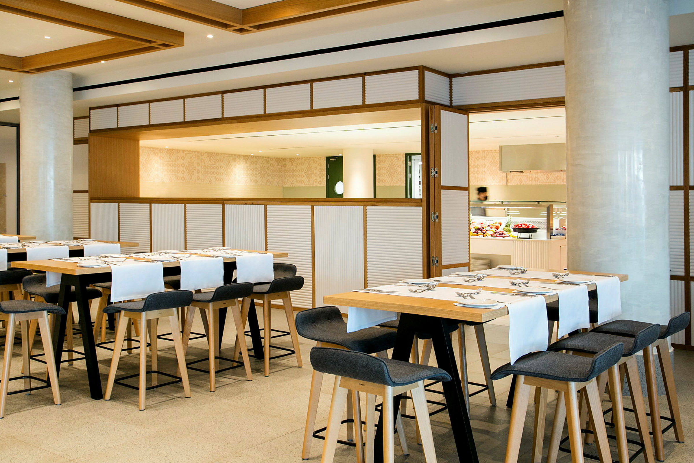 Moderne restaurant med stilfulde træborde og stole. (AI-genereret tekst)
