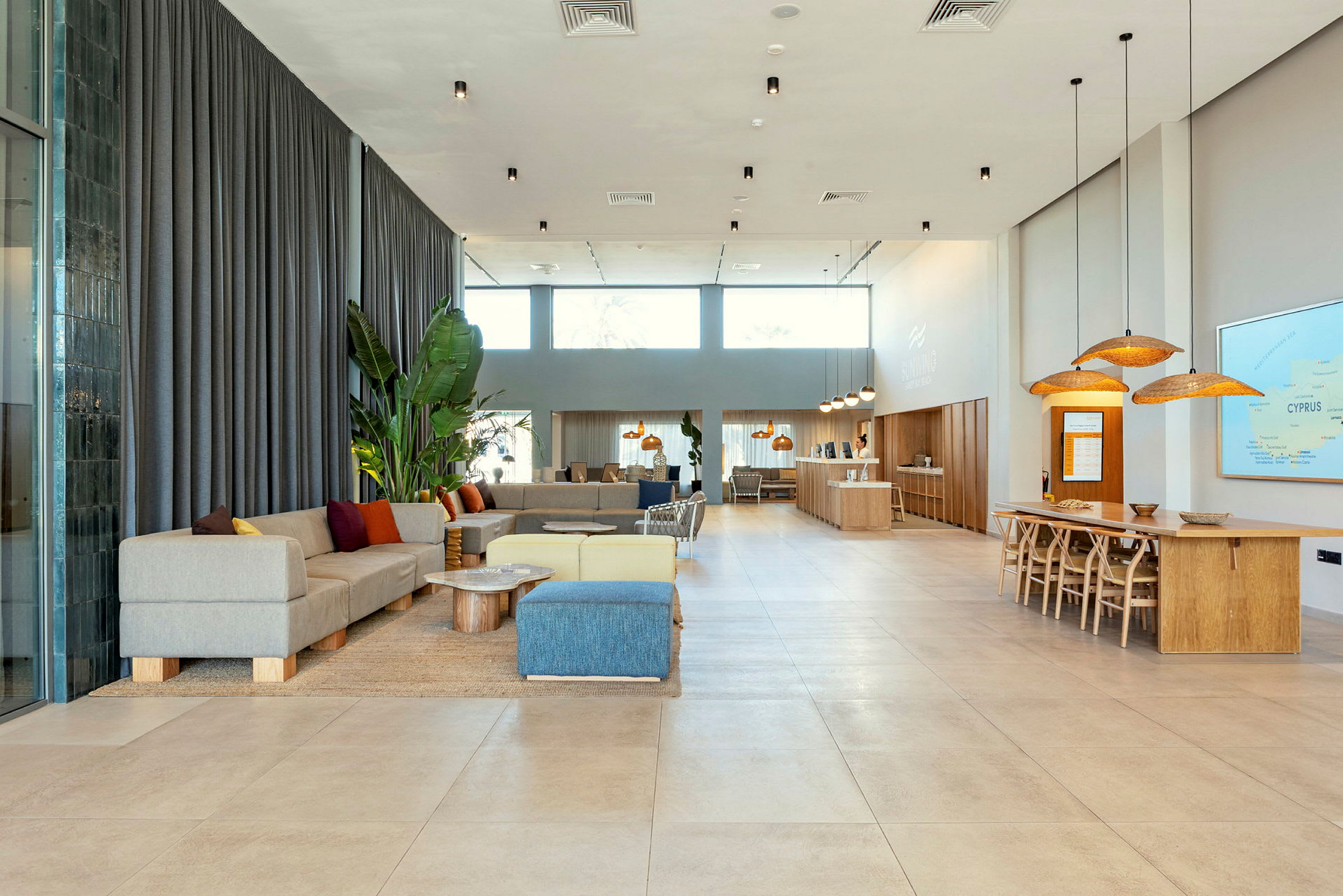 Et moderne og lyst indrettet hotellobbyområde med siddepladser, borde og en reception. (AI-genereret tekst)