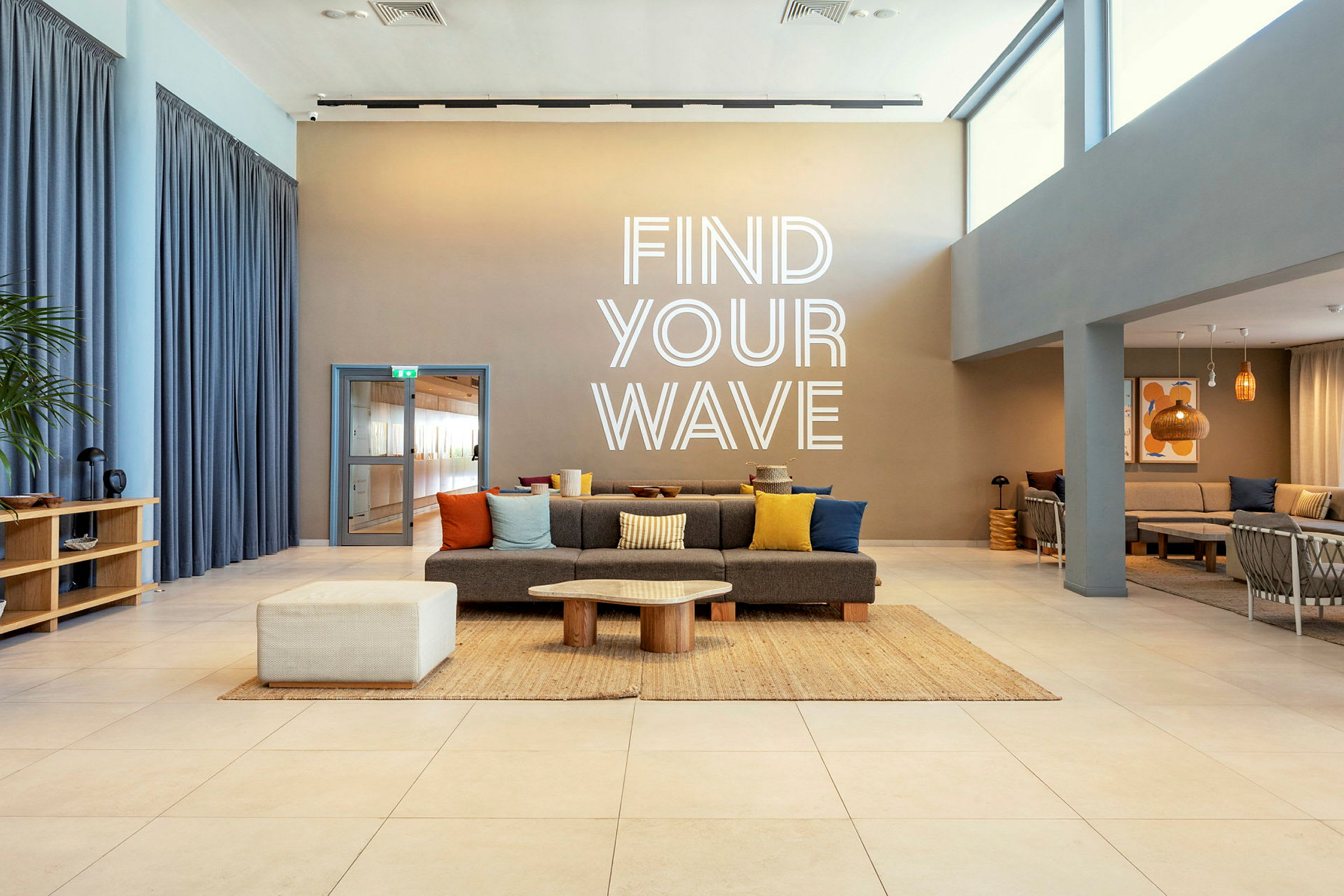 Et moderne rum med siddepladser og en tekst på væggen, der siger 'Find Your Wave'. (AI-genereret tekst)
