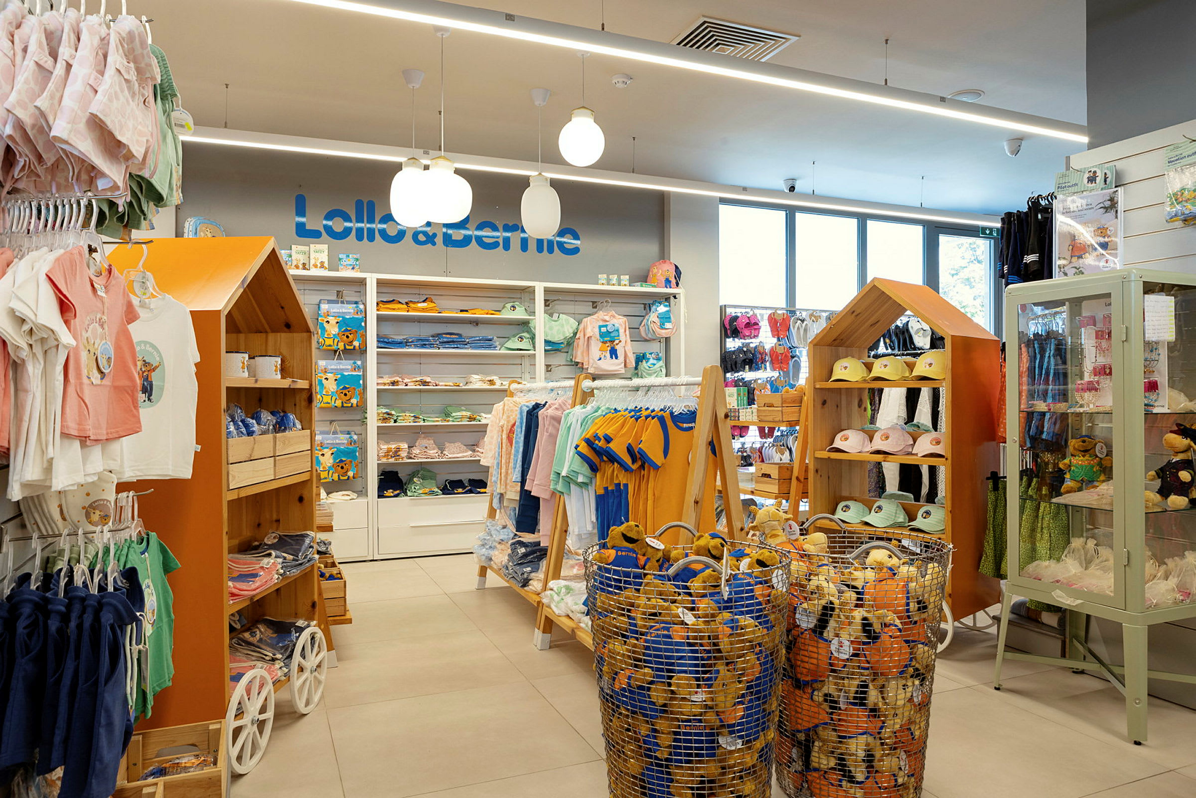 En butikinteriør med børnetøj og legetøj. Hylder, kurve og udstillingsskabe viser produkterne. (AI-genereret tekst)