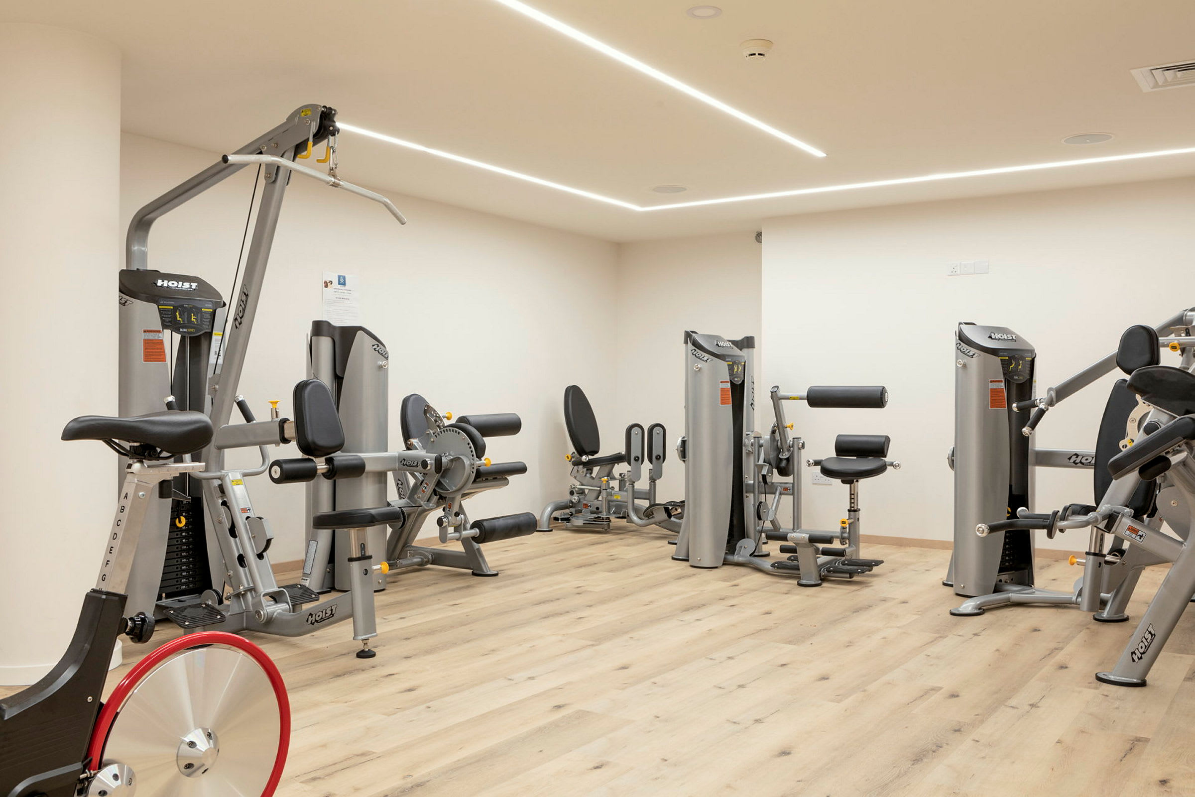 Fitnessrum med træningsmaskiner og udstyr. (AI-genereret tekst)