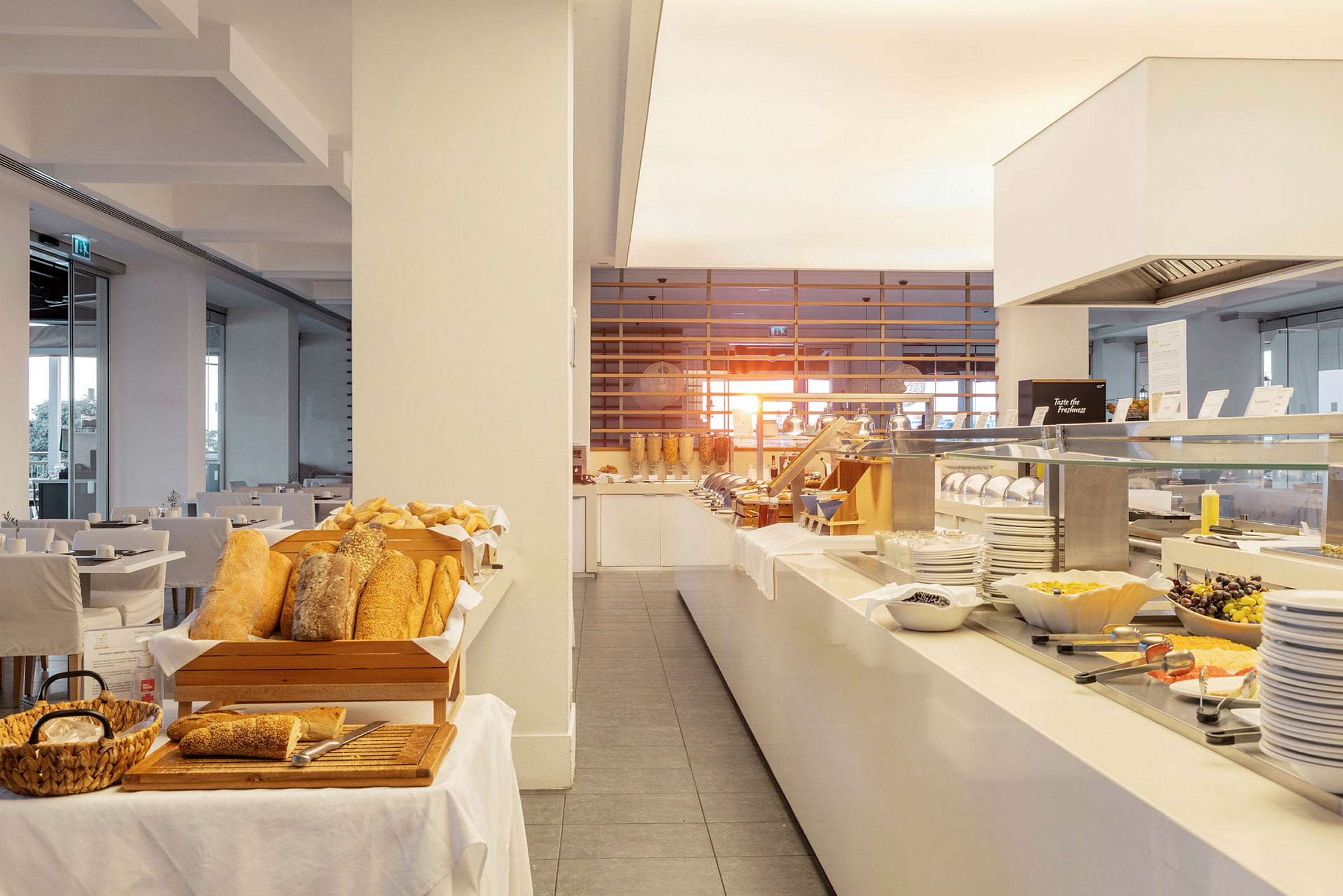 Billede af en hotelbuffet med brød, salat og andre morgenmadsingredienser. (AI-genereret tekst)