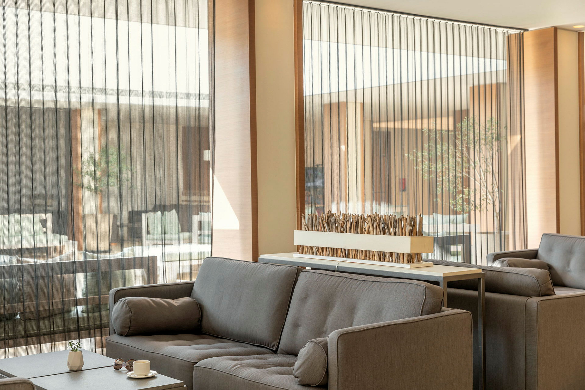 Moderne lounge med grå sofaer og dekorativ bordinstallation. (AI-genereret tekst)