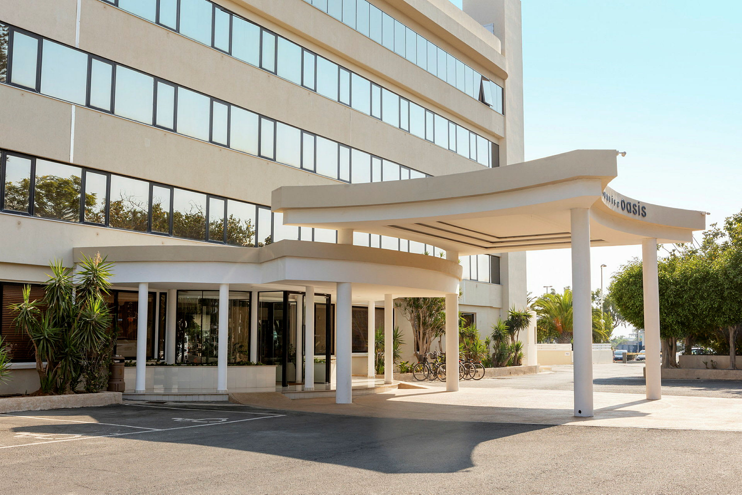 Hotelindgang med en overdækket vej foran og cykler parkeret ved siden af. (AI-genereret tekst)
