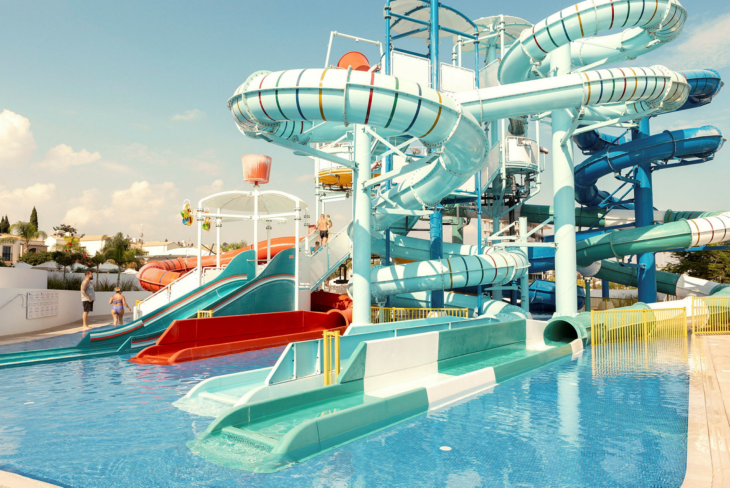 Billede af et vandland med flere vandrutsjebaner og en pool. (AI-genereret tekst)