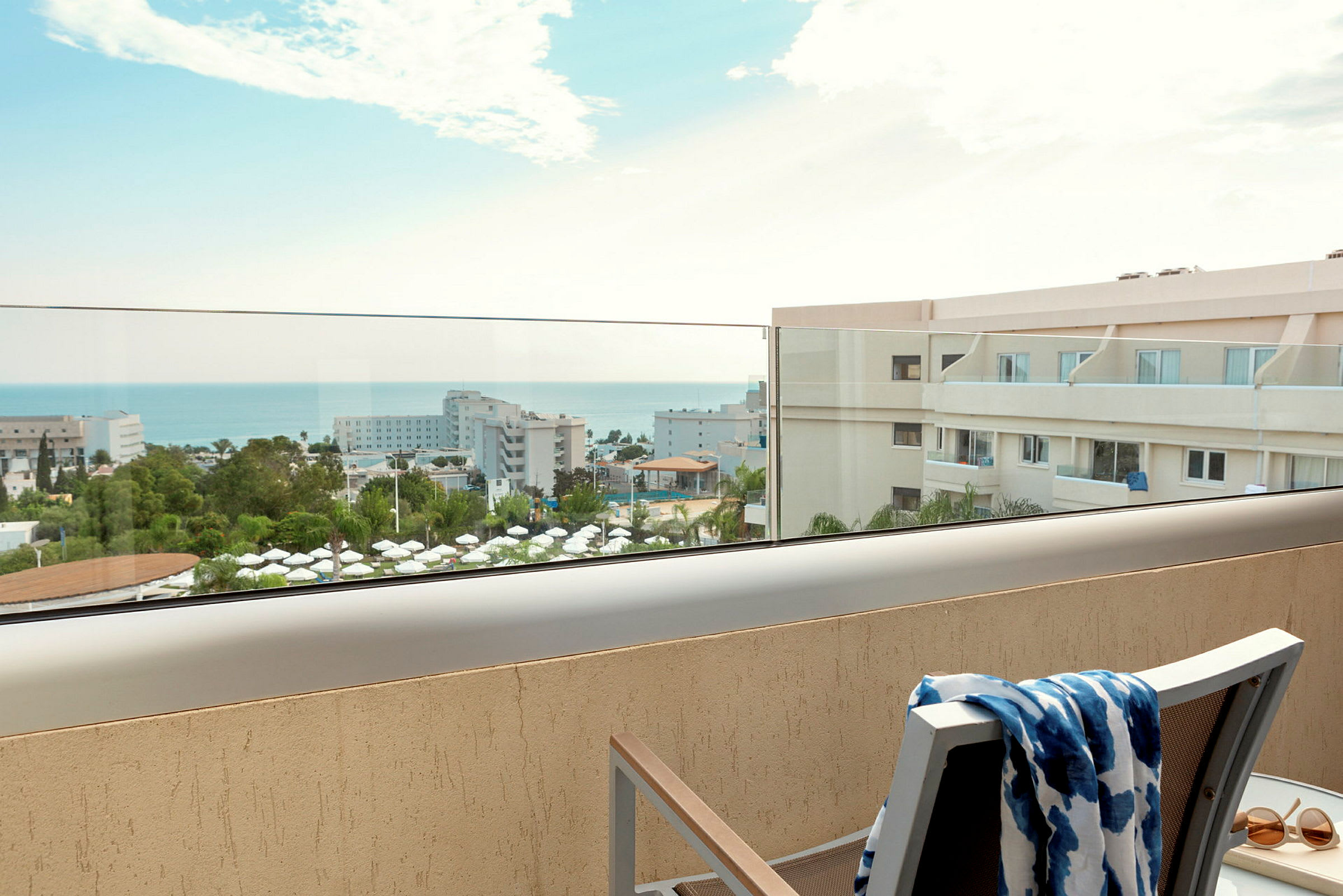 Udsigt fra balkon over hotelområde og hav. (AI-genereret tekst)