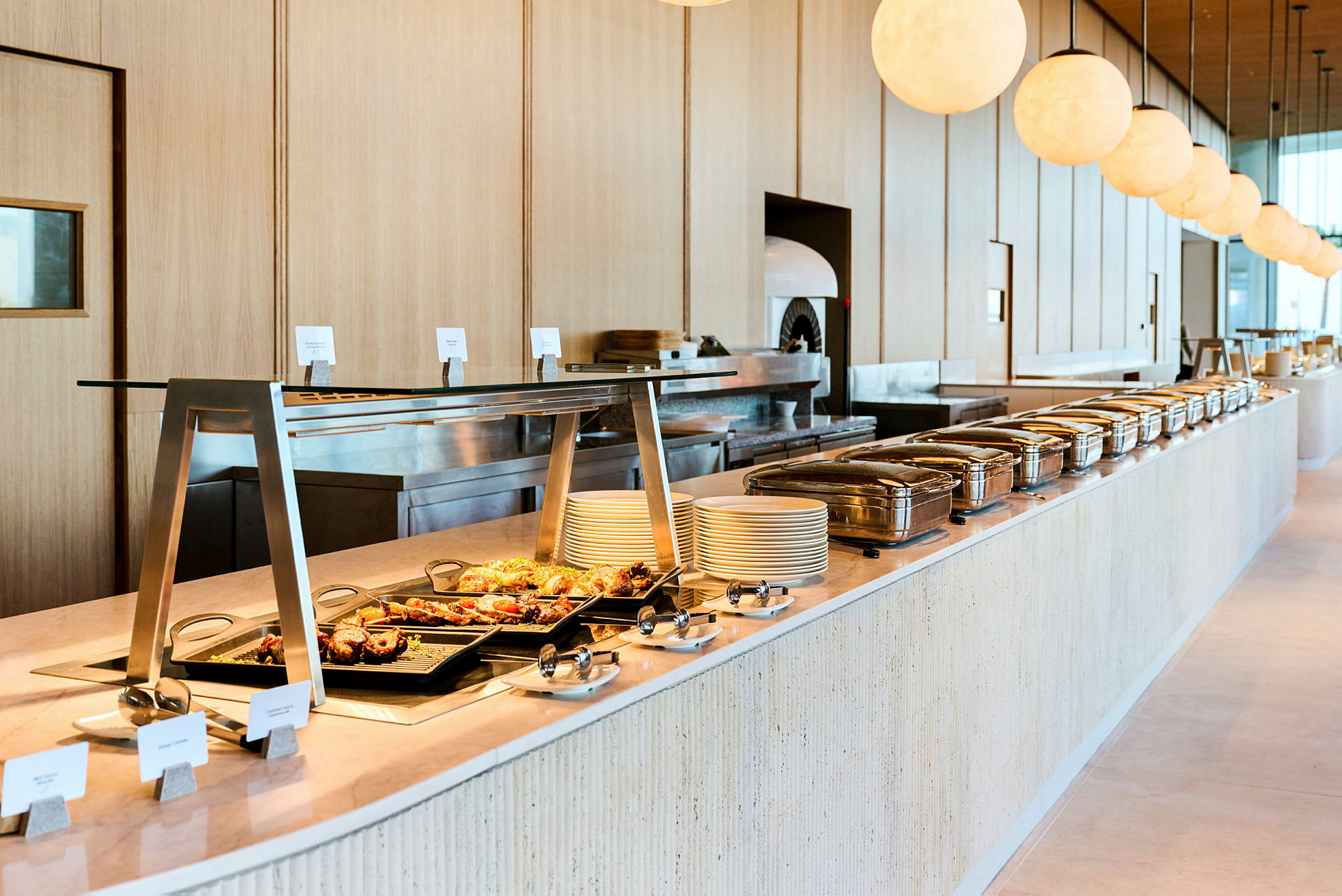 En buffet med forskellige retter, tallerkener og varm madudstyr. (AI-genereret tekst)