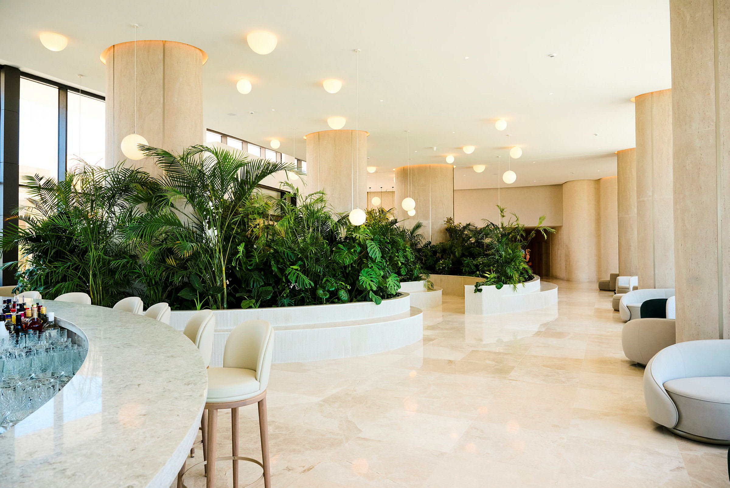 Hotellets lobby med moderne, lyse møbler og frodige plantearrangementer. (AI-genereret tekst)