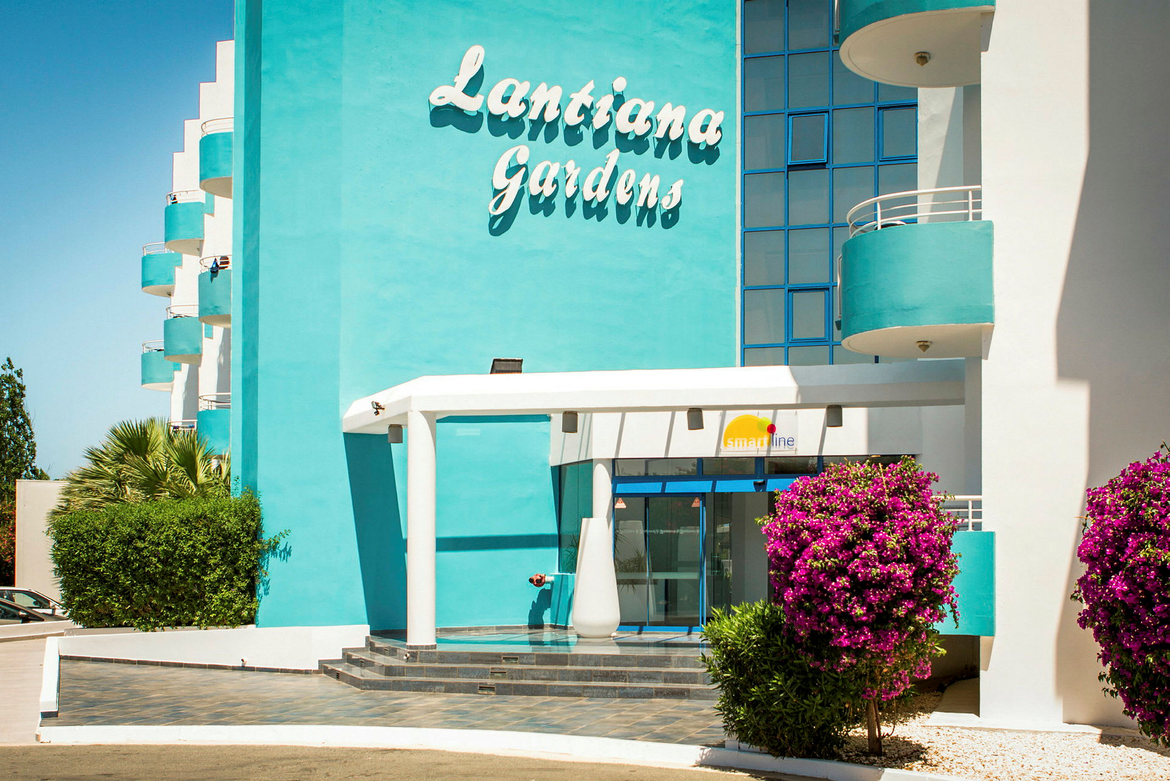 Hotelbygning med et skilt, hvor der står 'Lantiana Gardens'. (AI-genereret tekst)