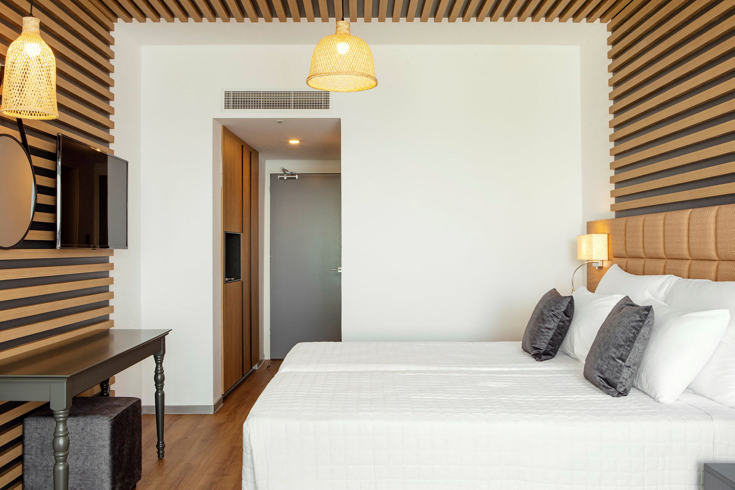 Moderne hotelværelse med dobbeltseng, trædekorationer og lamper. (AI-genereret tekst)