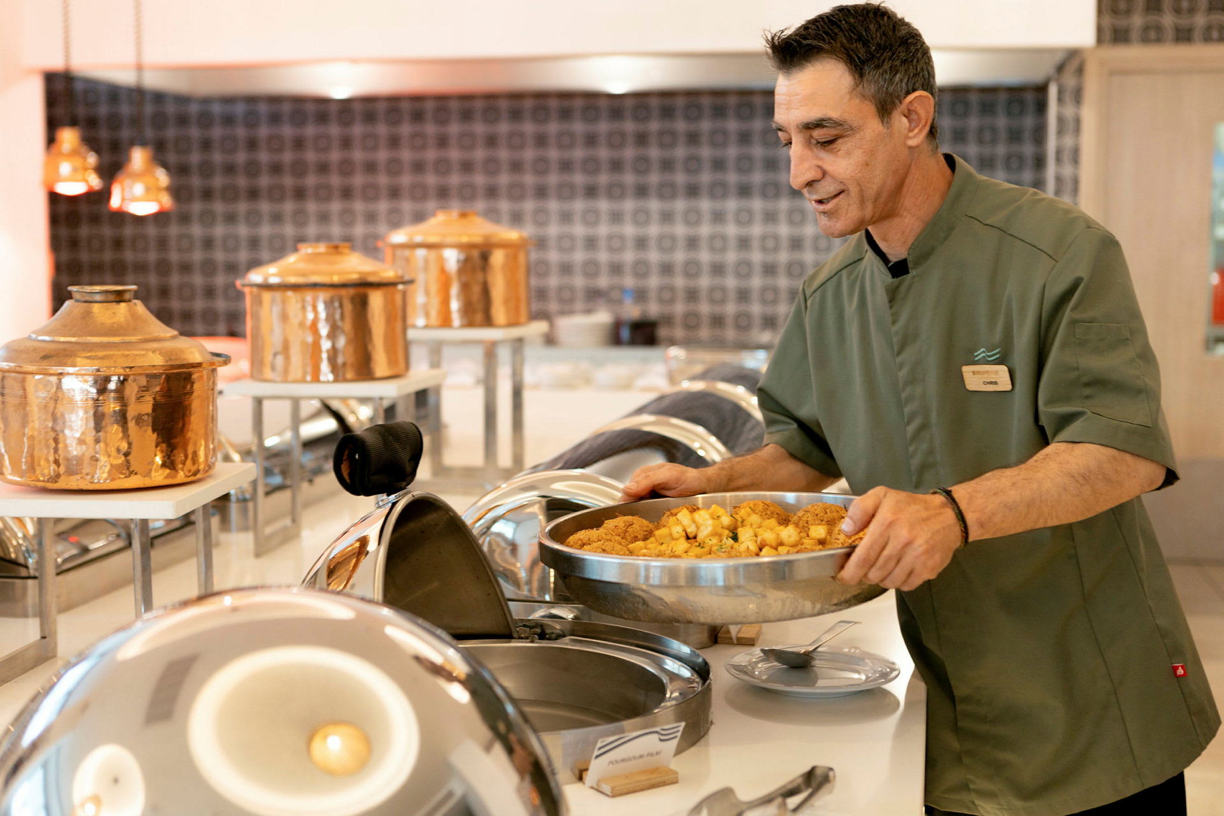 Personen serverer mad ved en buffetbænk. (AI-genereret tekst)