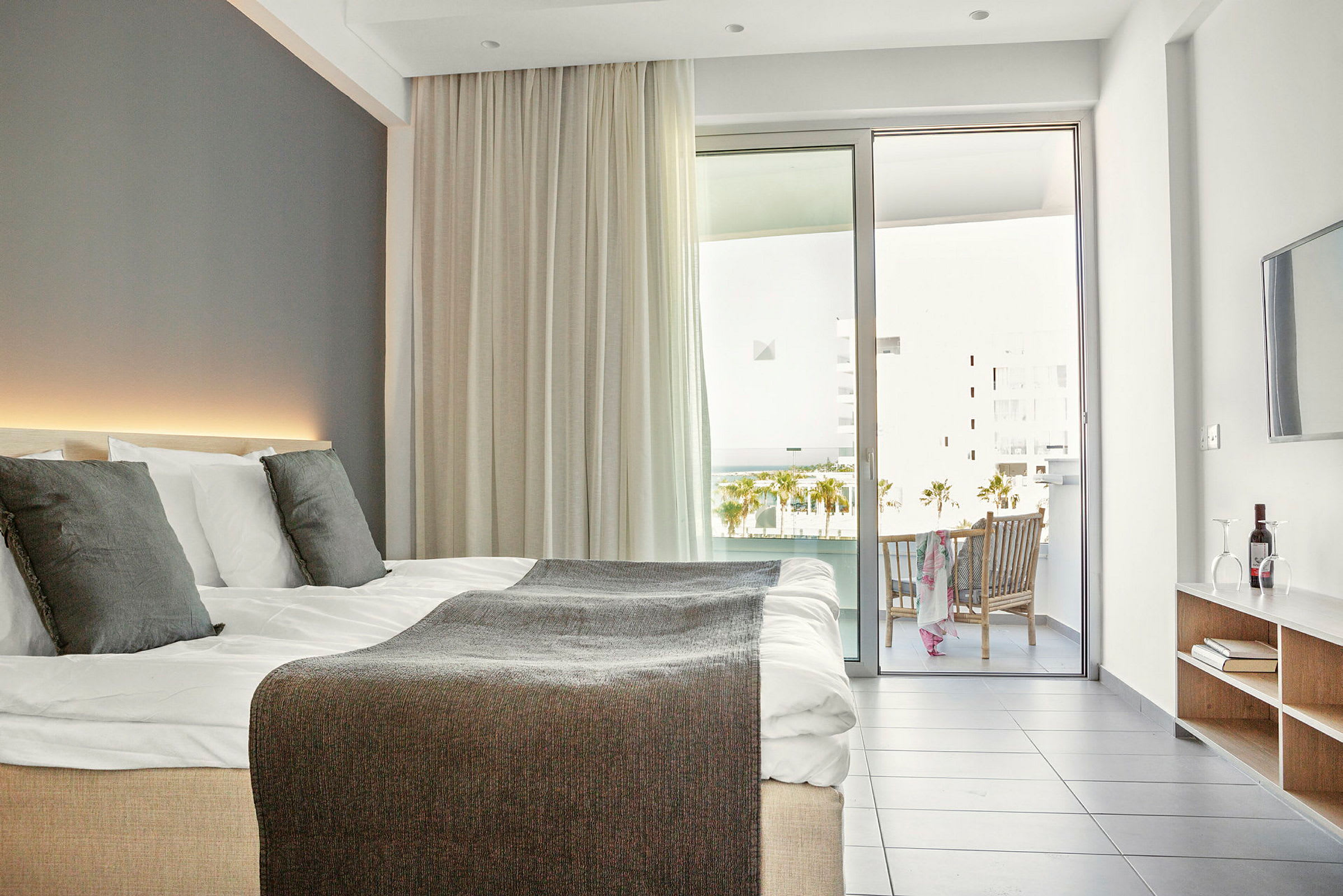 Moderne hotelværelse med dobbeltseng, altan og siddeområde. (AI-genereret tekst)