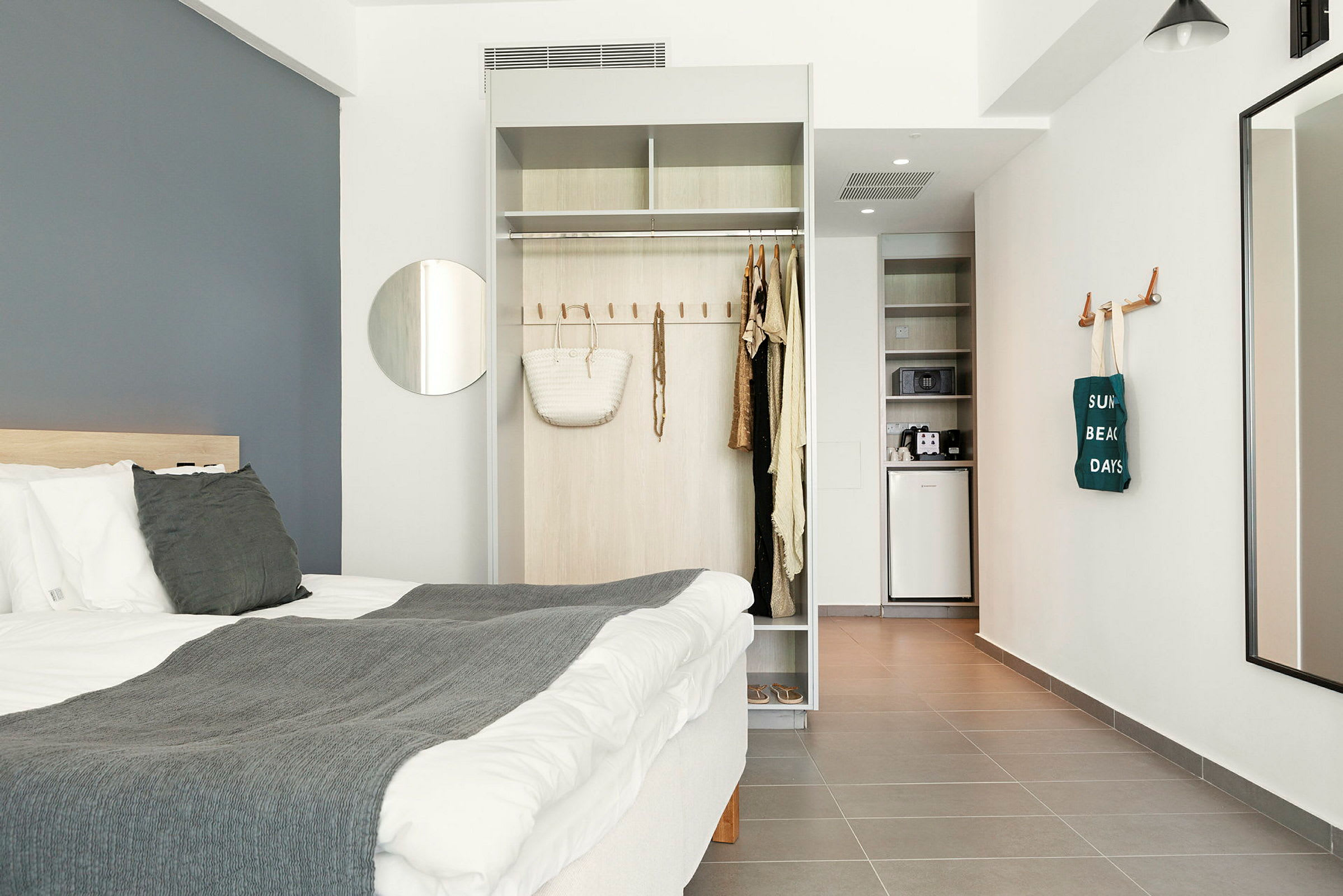 Moderne hotelværelse med seng, garderobe og lille tekøkken. (AI-genereret tekst)