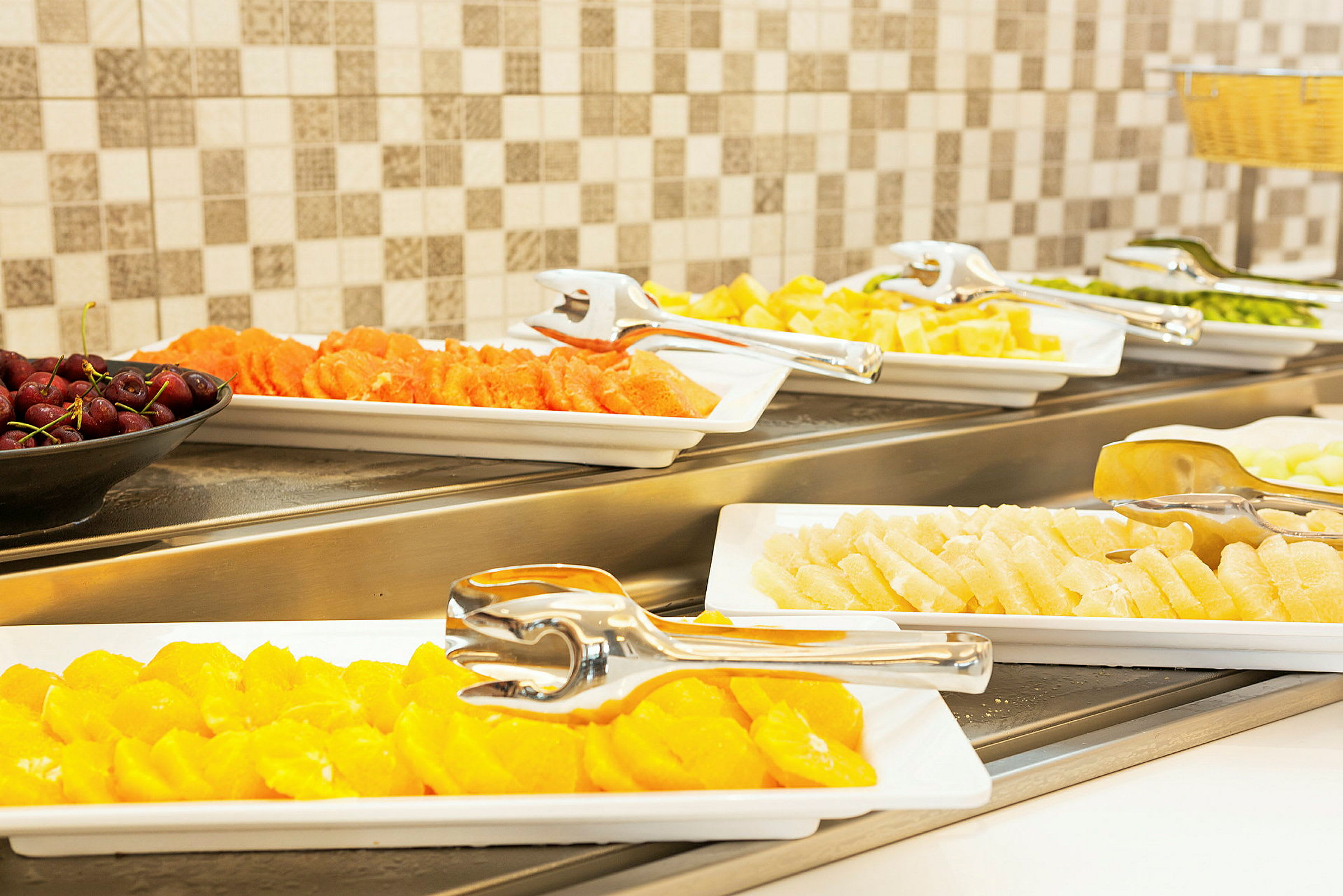 Buffet med forskellige typer frisk frugt på serveringsfade. (AI-genereret tekst)