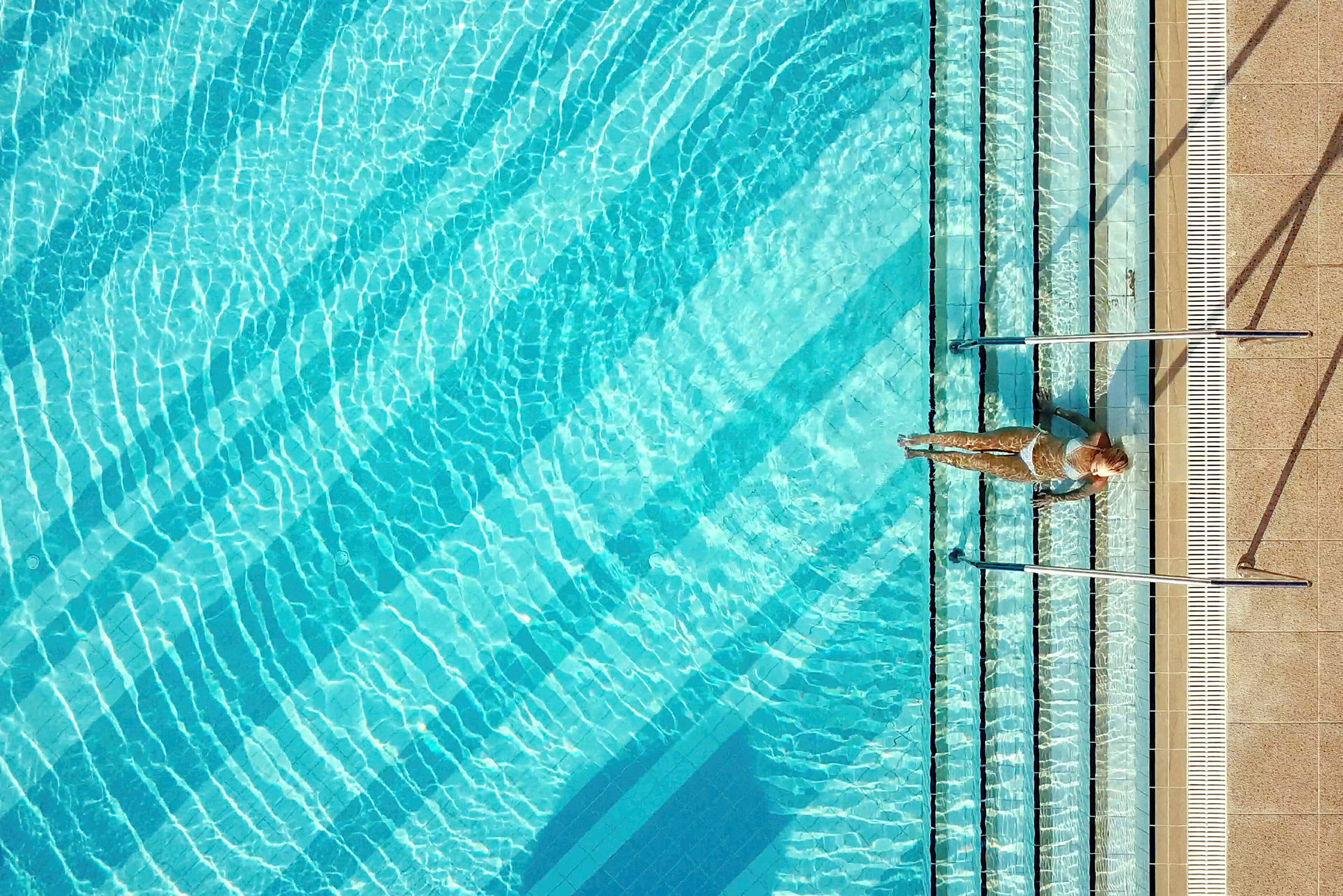Person ved kanten af en swimmingpool. (AI-genereret tekst)