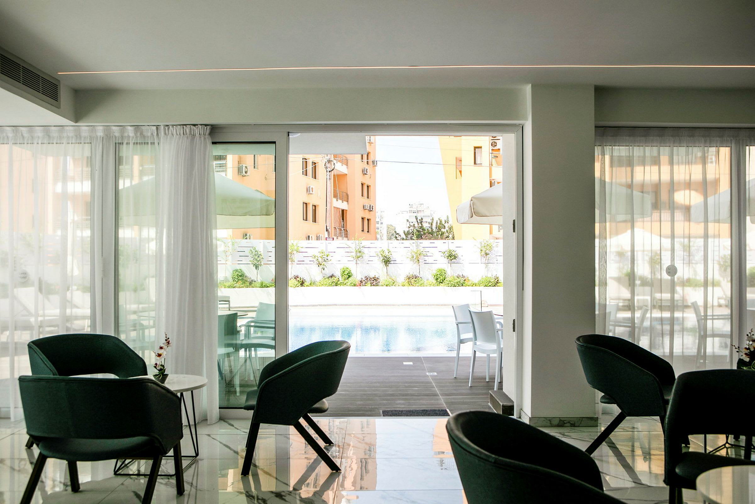 Et rum med siddepladser foran en glasdør, der fører ud til en pool og en terrasse. (AI-genereret tekst)