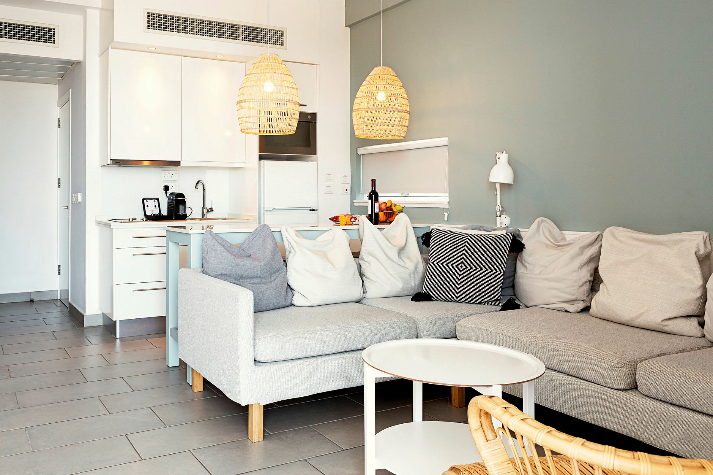 En moderne indretning med sofa, sofabord og et køkken i baggrunden. (AI-genereret tekst)