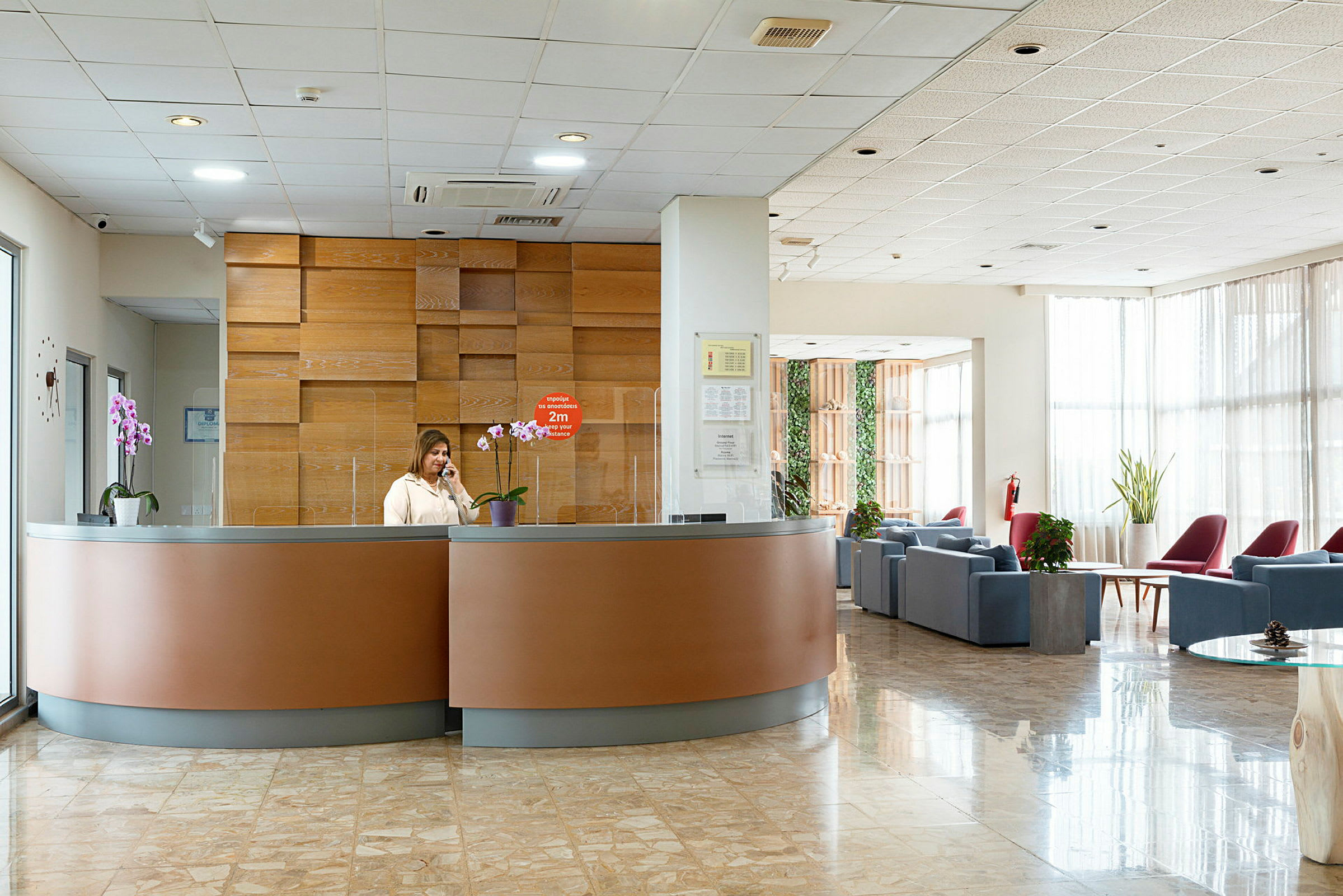 Reception i et moderne hotel med siddeområde i baggrunden. (AI-genereret tekst)