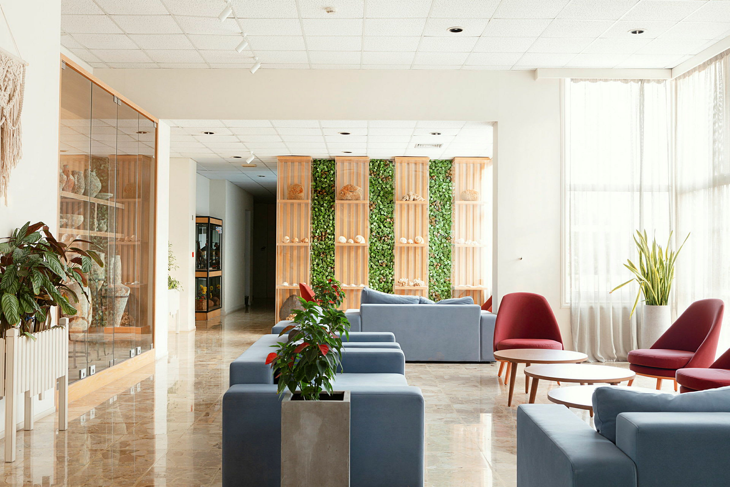 Hotellets lobby med moderne møbler og planteindretning. (AI-genereret tekst)