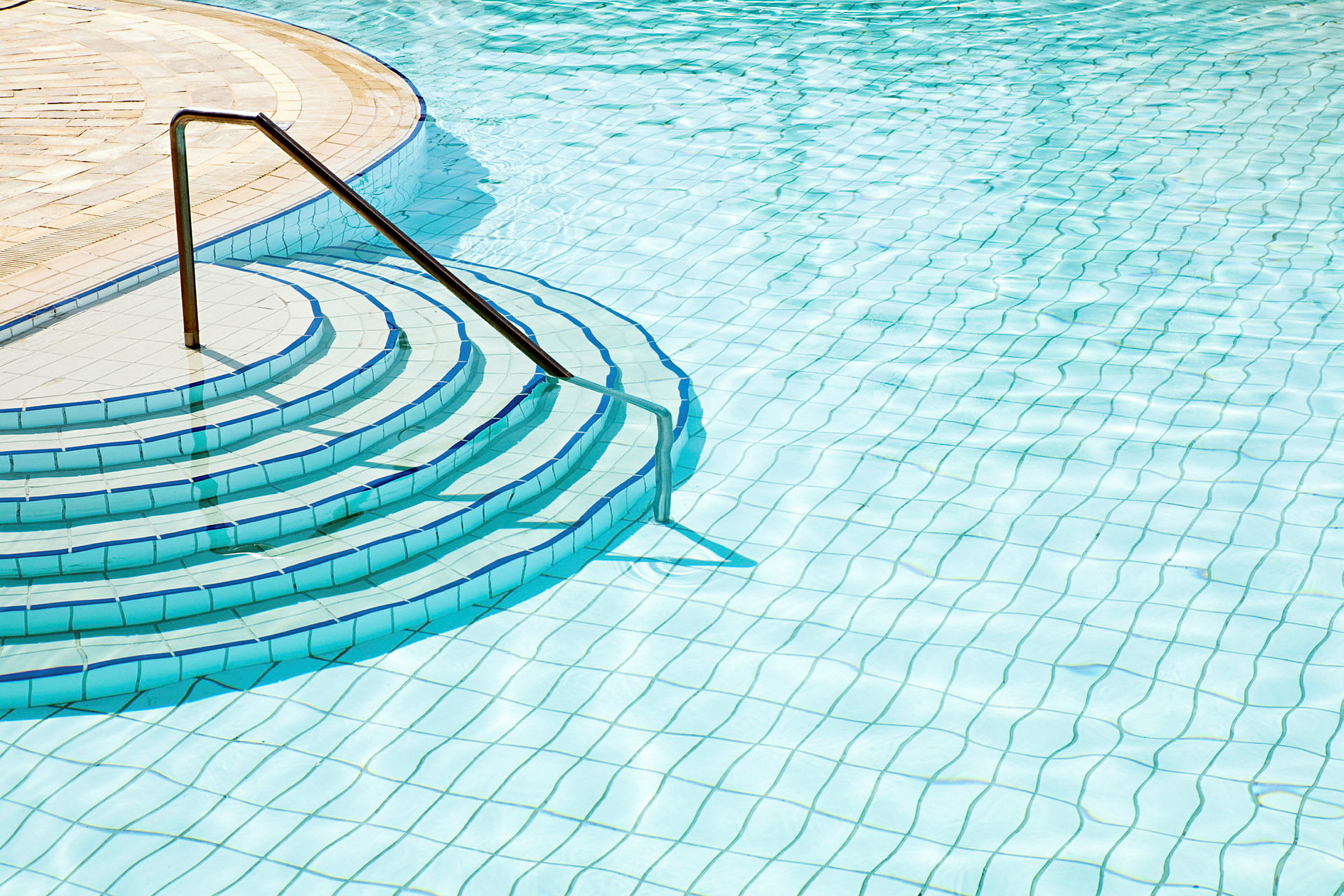 Trin der fører ned i en udendørs swimmingpool. (AI-genereret tekst)