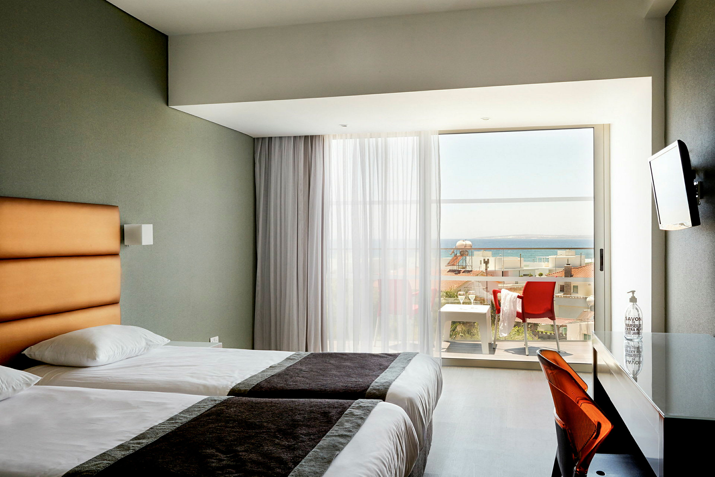 Hotelværelse med to enkeltsenge og balkon med havudsigt. (AI-genereret tekst)